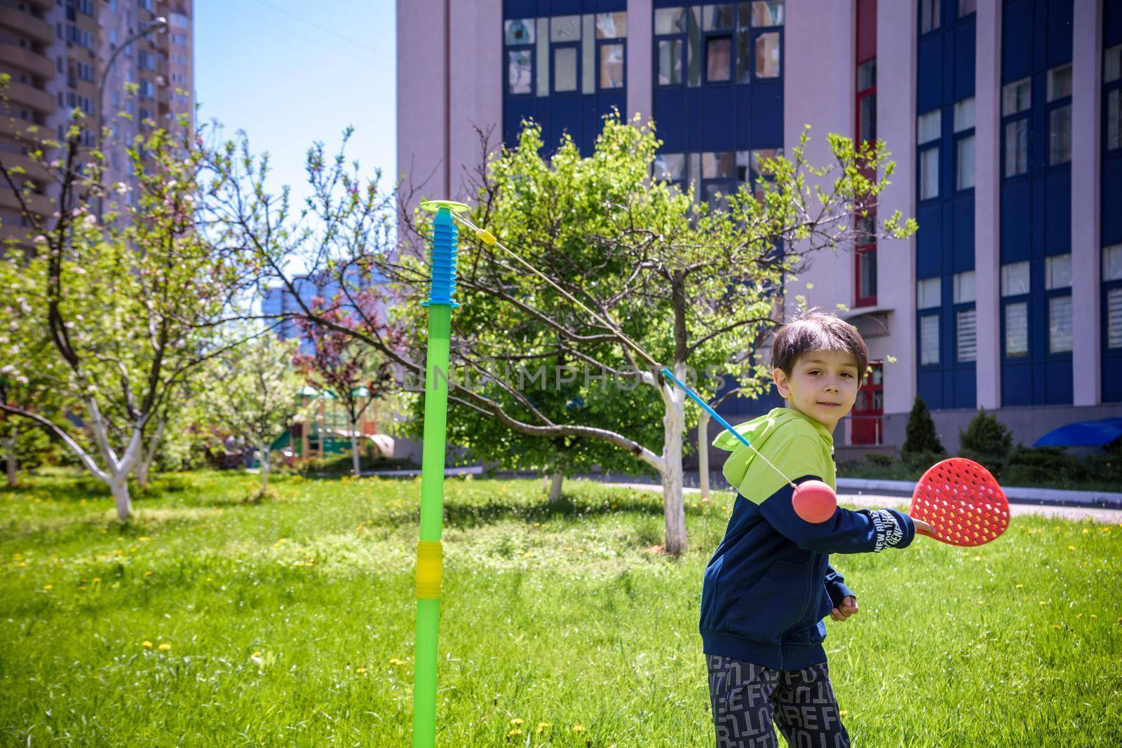 Happy boy is playing tetherball swing ball game in summer camping. Happy leisure healthy active time outdoors concept.