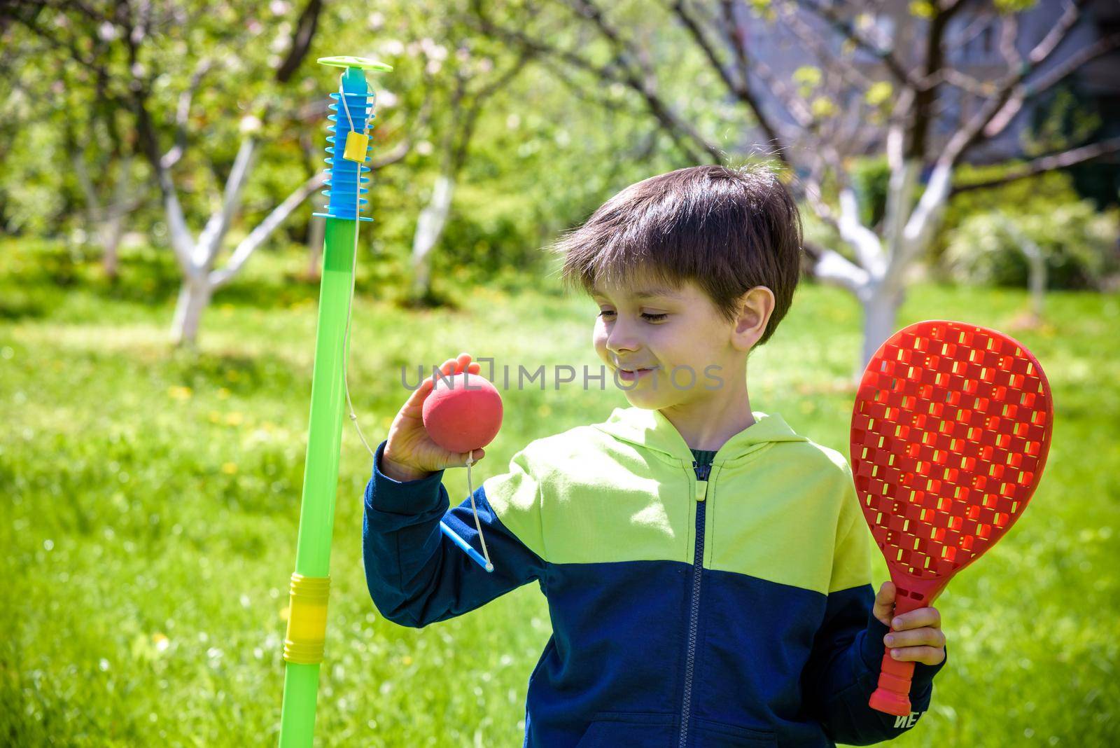 Happy boy is playing tetherball swing ball game in summer campin by Kobysh