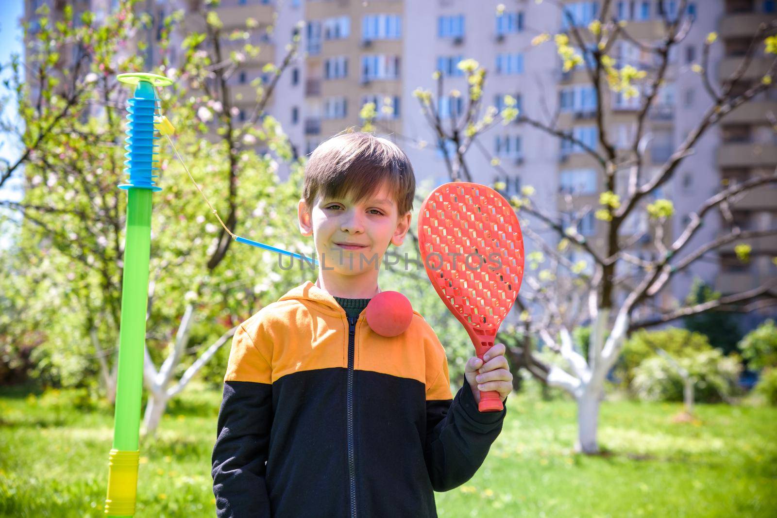 Happy boy is playing tetherball swing ball game in summer campin by Kobysh