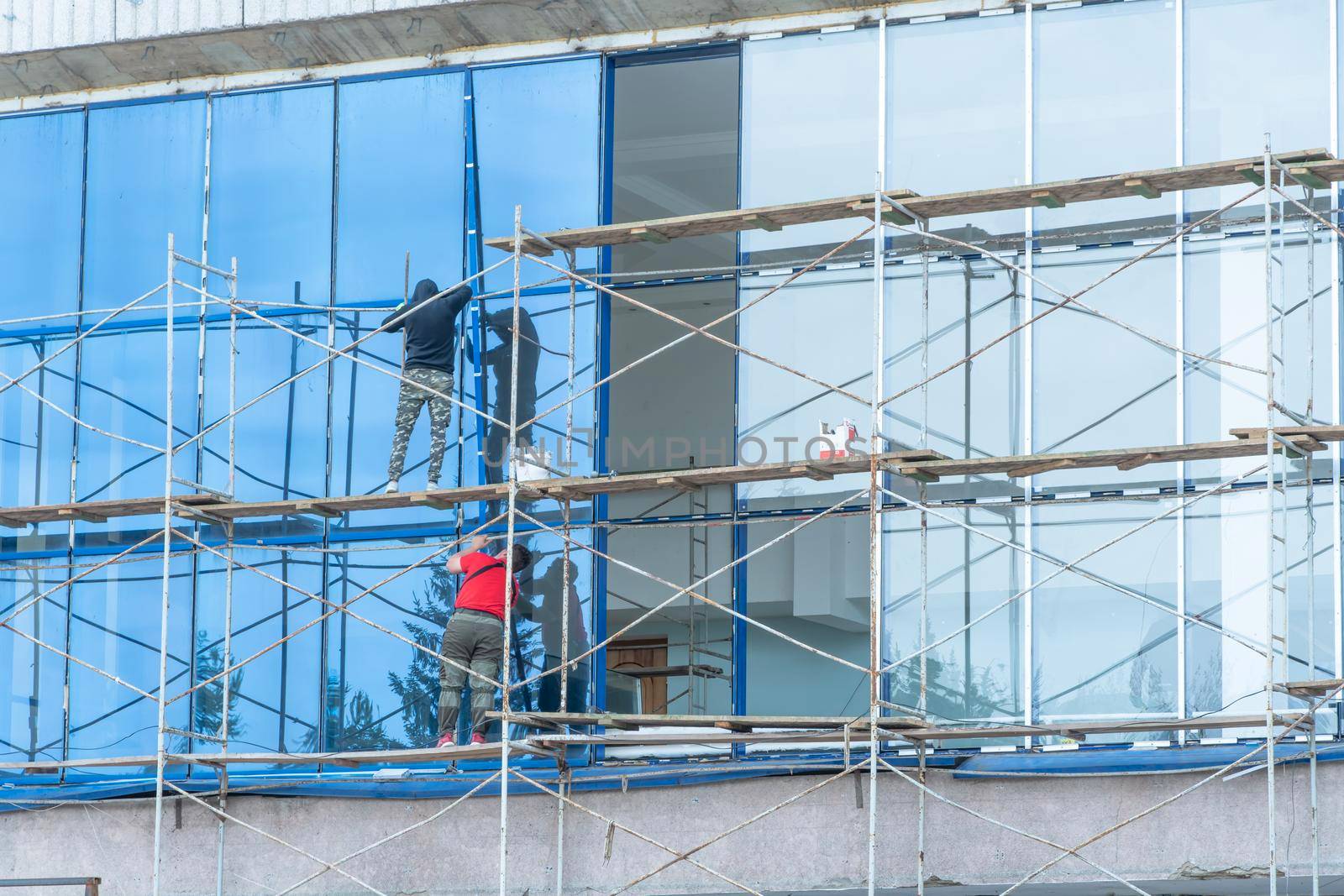 Moscow, Russia,05,10,2021:Restoration, reconstruction and repair of the building. Construction workers are standing on scaffolding at the structure.Housing Restoration Construction Site