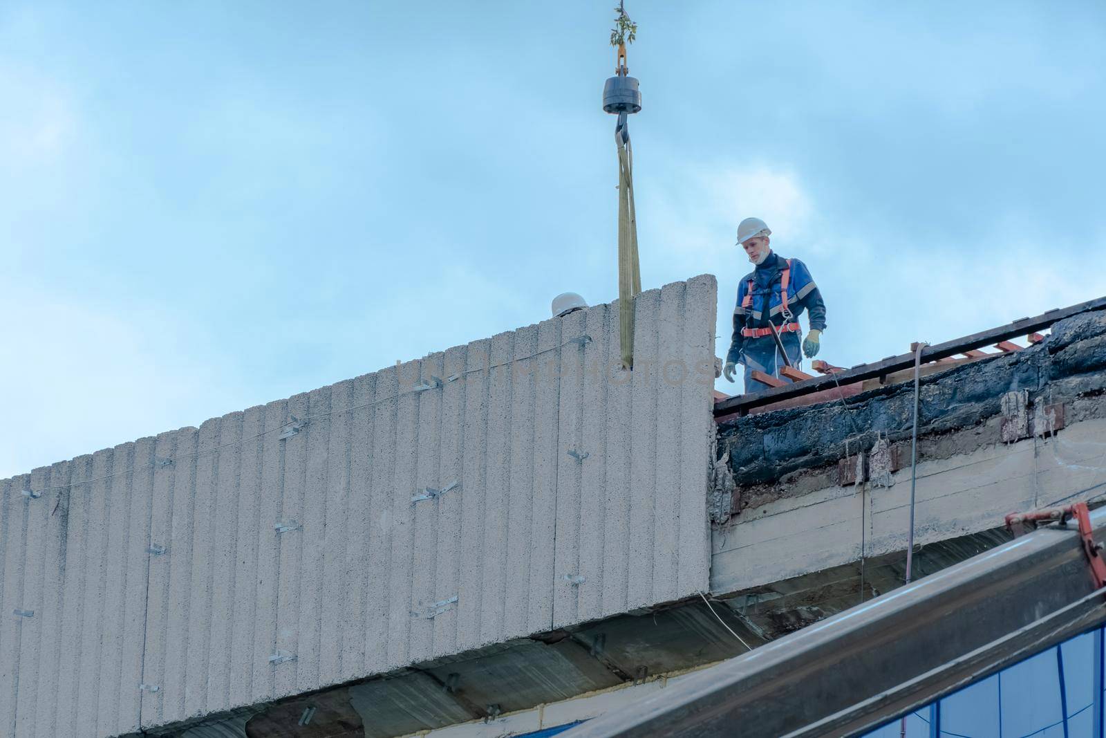 Moscow,Russia,05,10,2021:Restoration,reconstruction and repair of the building.Construction workers in hard hats install concrete slabs on the roof of the structure.Housing Restoration Construction