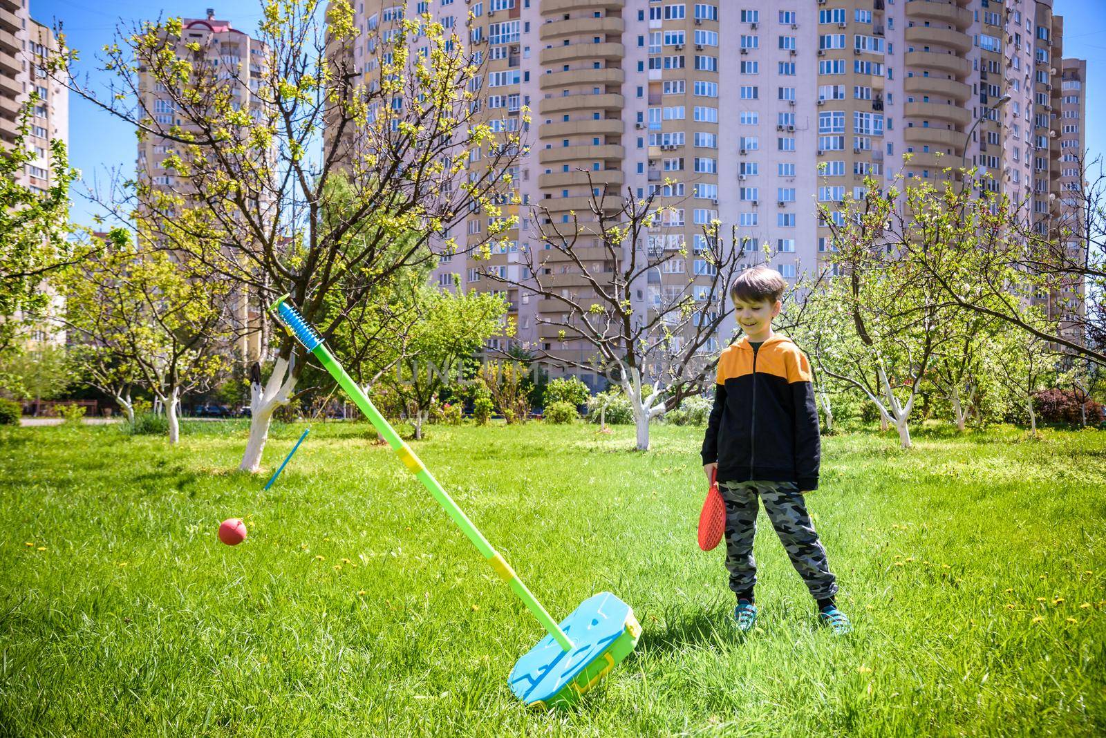 Happy boy is playing tetherball swing ball game in summer camping. Happy leisure healthy active time outdoors concept by Kobysh