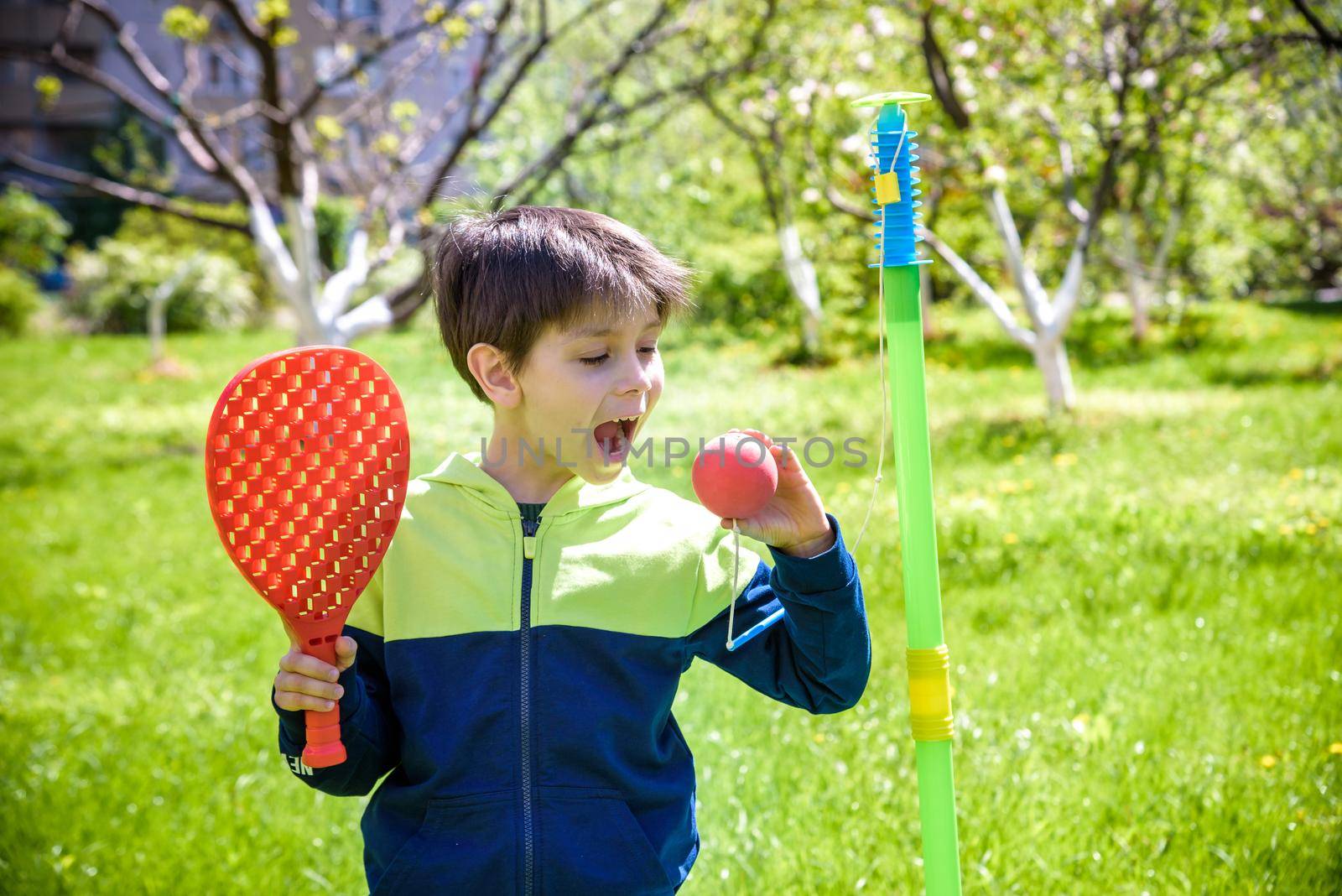 Happy boy is playing tetherball swing ball game in summer camping. Happy leisure healthy active time outdoors concept by Kobysh