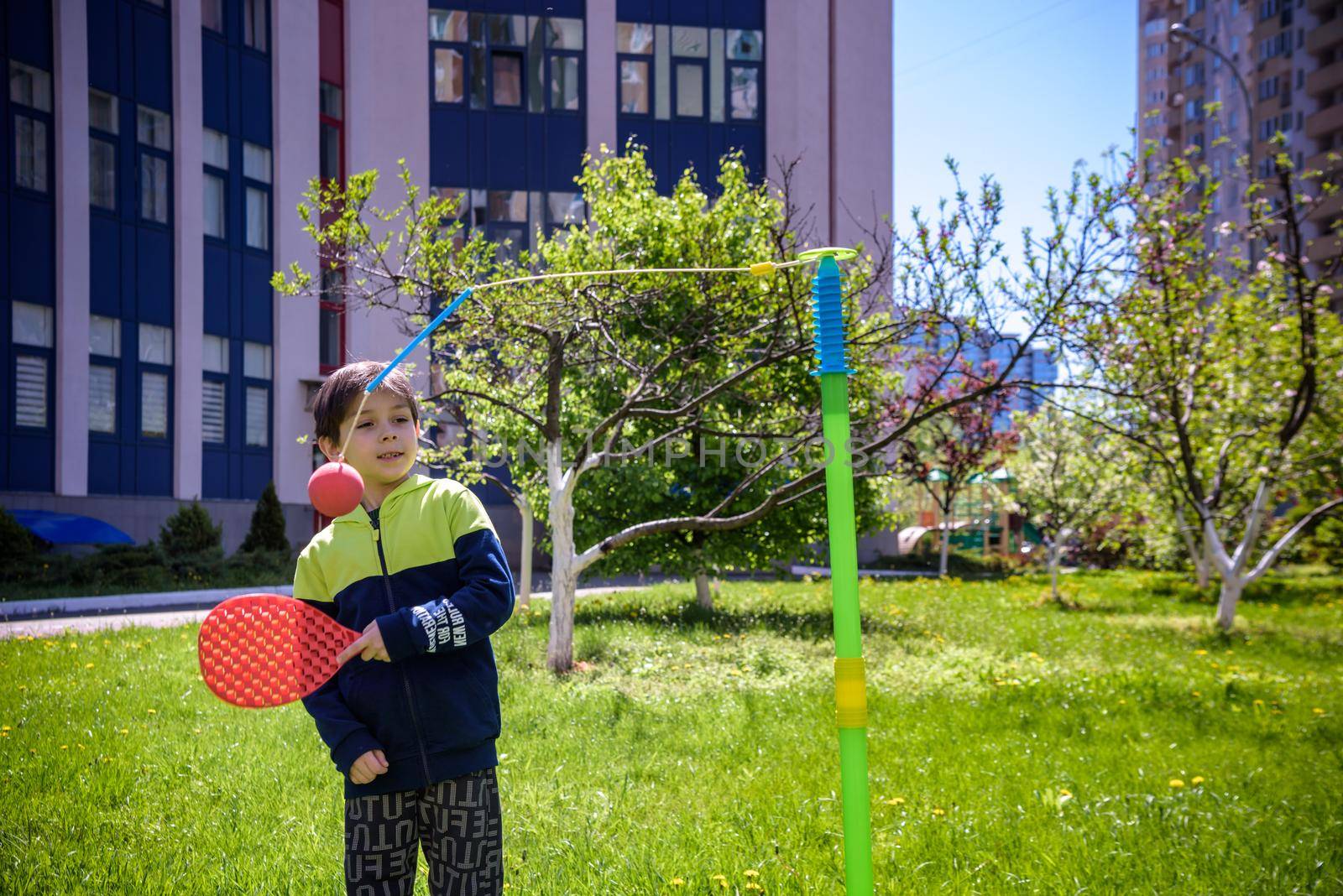 Happy boy is playing tetherball swing ball game in summer camping. Happy leisure healthy active time outdoors concept.