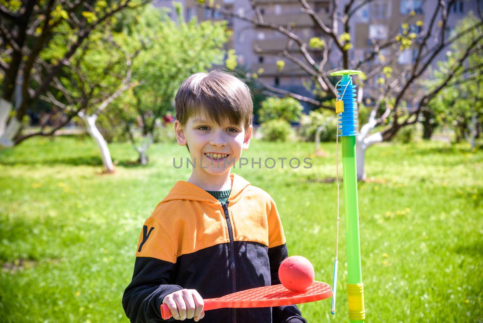Happy boy is playing tetherball swing ball game in summer camping. Happy leisure healthy active time outdoors concept.