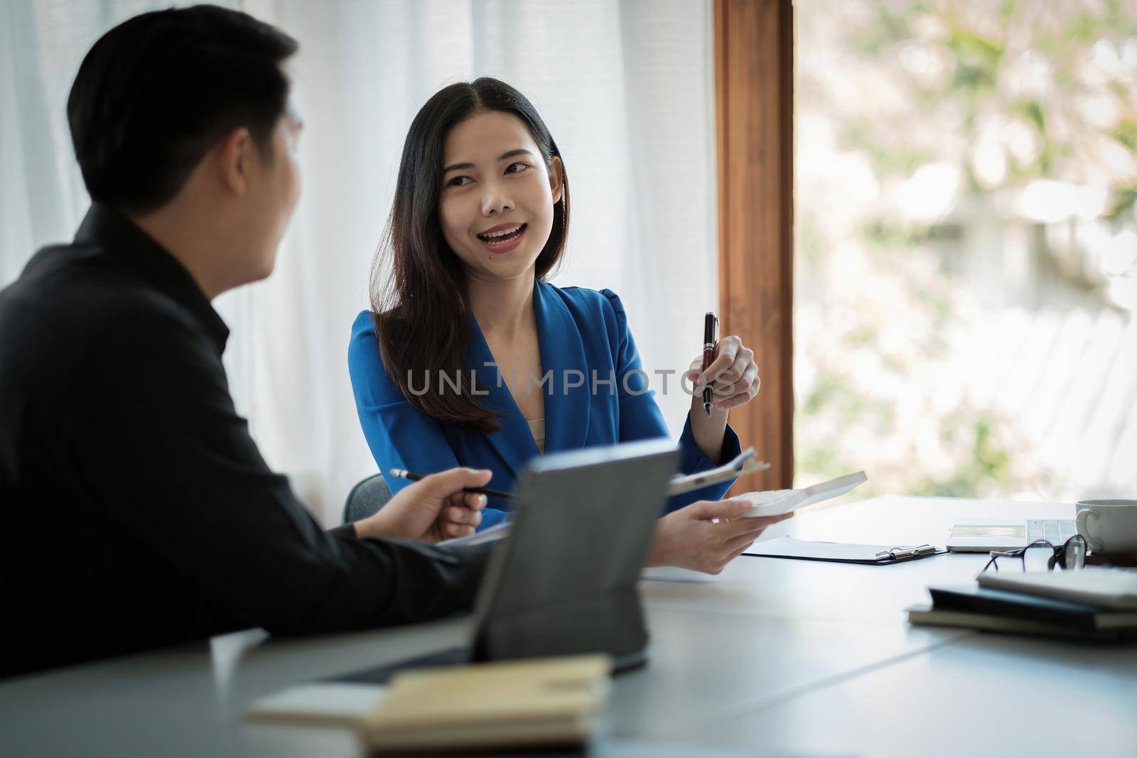 Two business asian Talking Discussing with coworker planning analyzing financial document data charts and graphs in Meeting and successful teamwork Concept