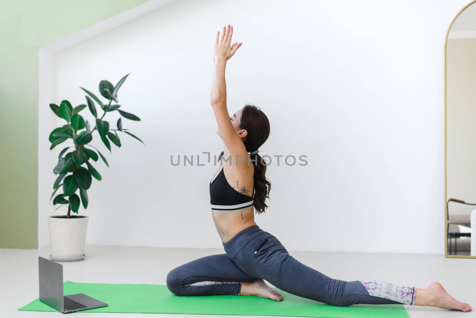 Young woman doing stretching, keeping fit during pandemic and quarantine
