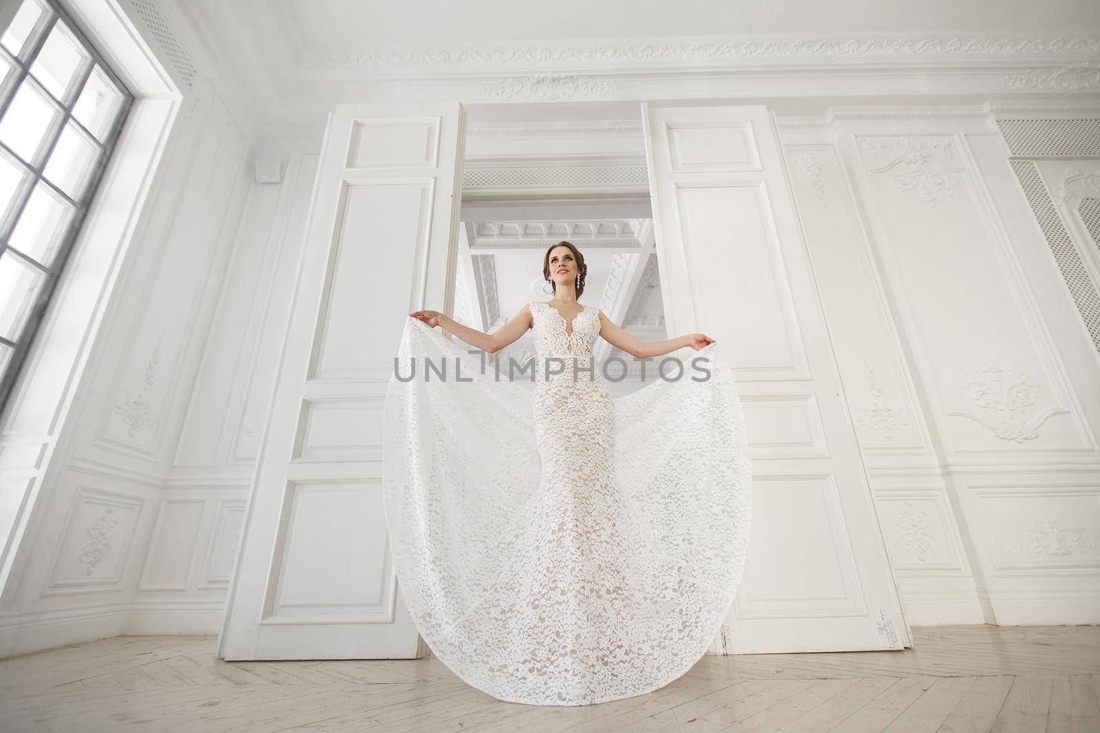 Beautiful bride posing in wedding dress in a white photo Studio.