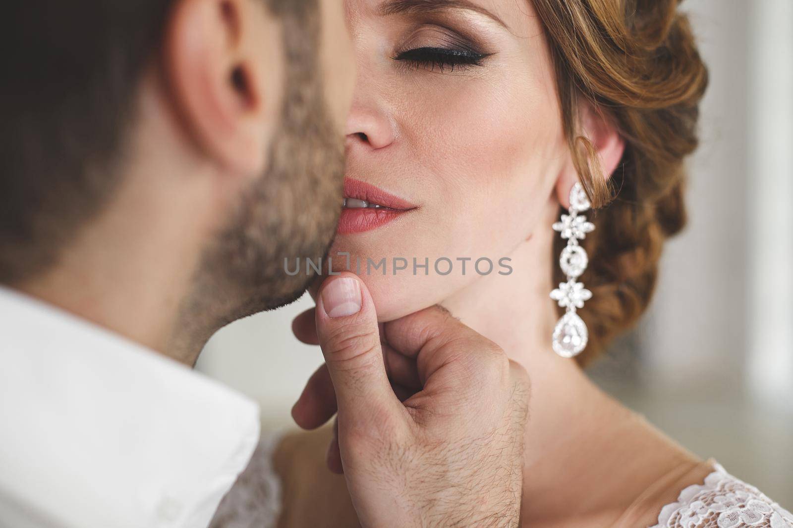 Chic wedding couple groom and bride posing in a white Studio.