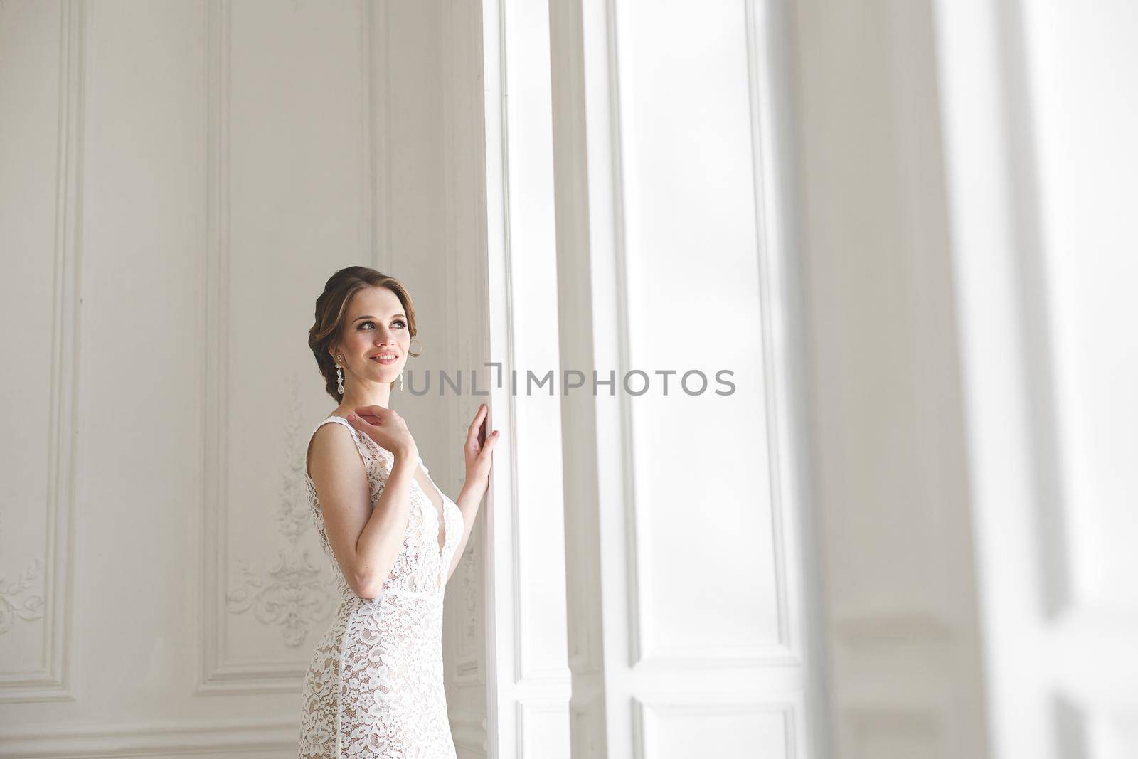 Beautiful bride posing in wedding dress in a white photo Studio.