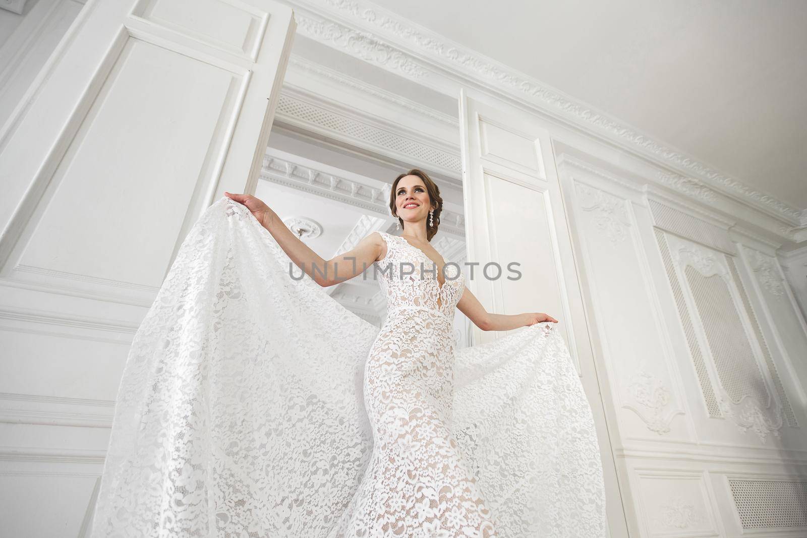 Beautiful bride posing in wedding dress in a white photo Studio. by StudioPeace