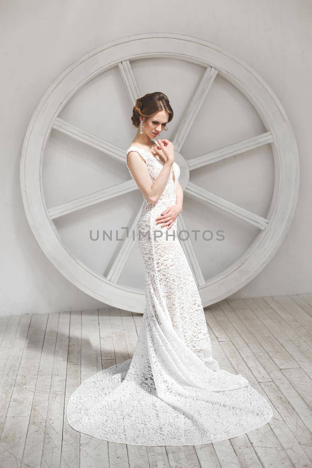 Beautiful bride posing in wedding dress in a white photo Studio. by StudioPeace