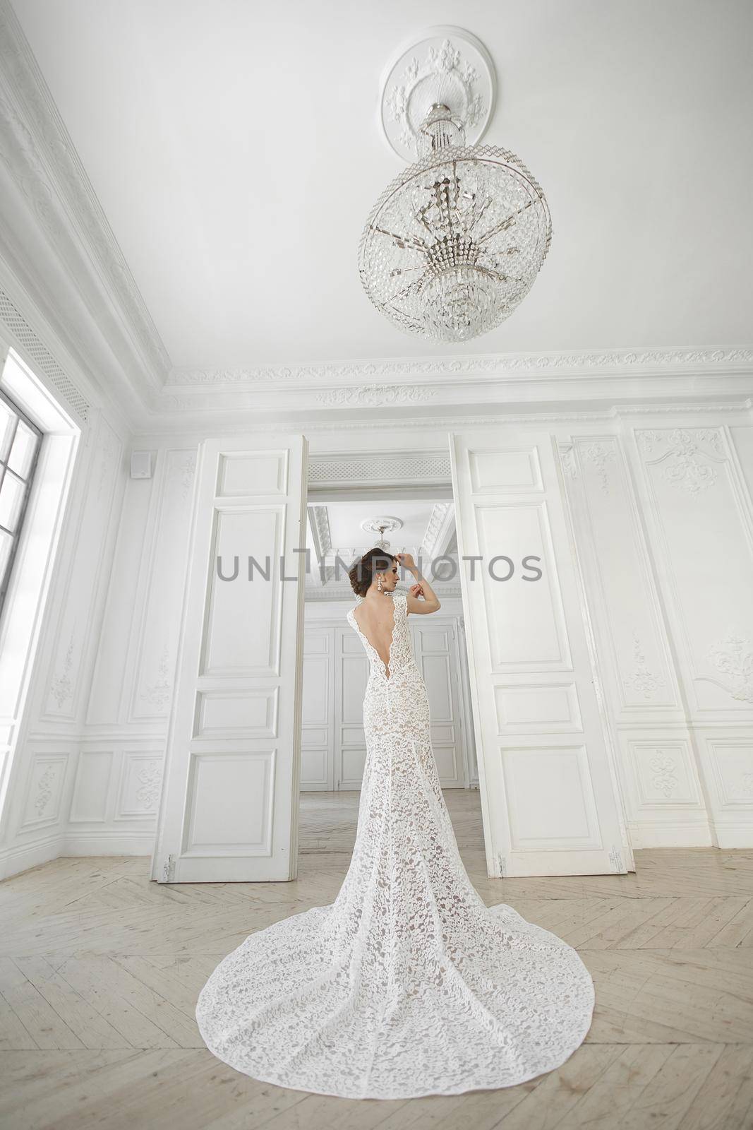 Beautiful bride posing in wedding dress in a white photo Studio. by StudioPeace