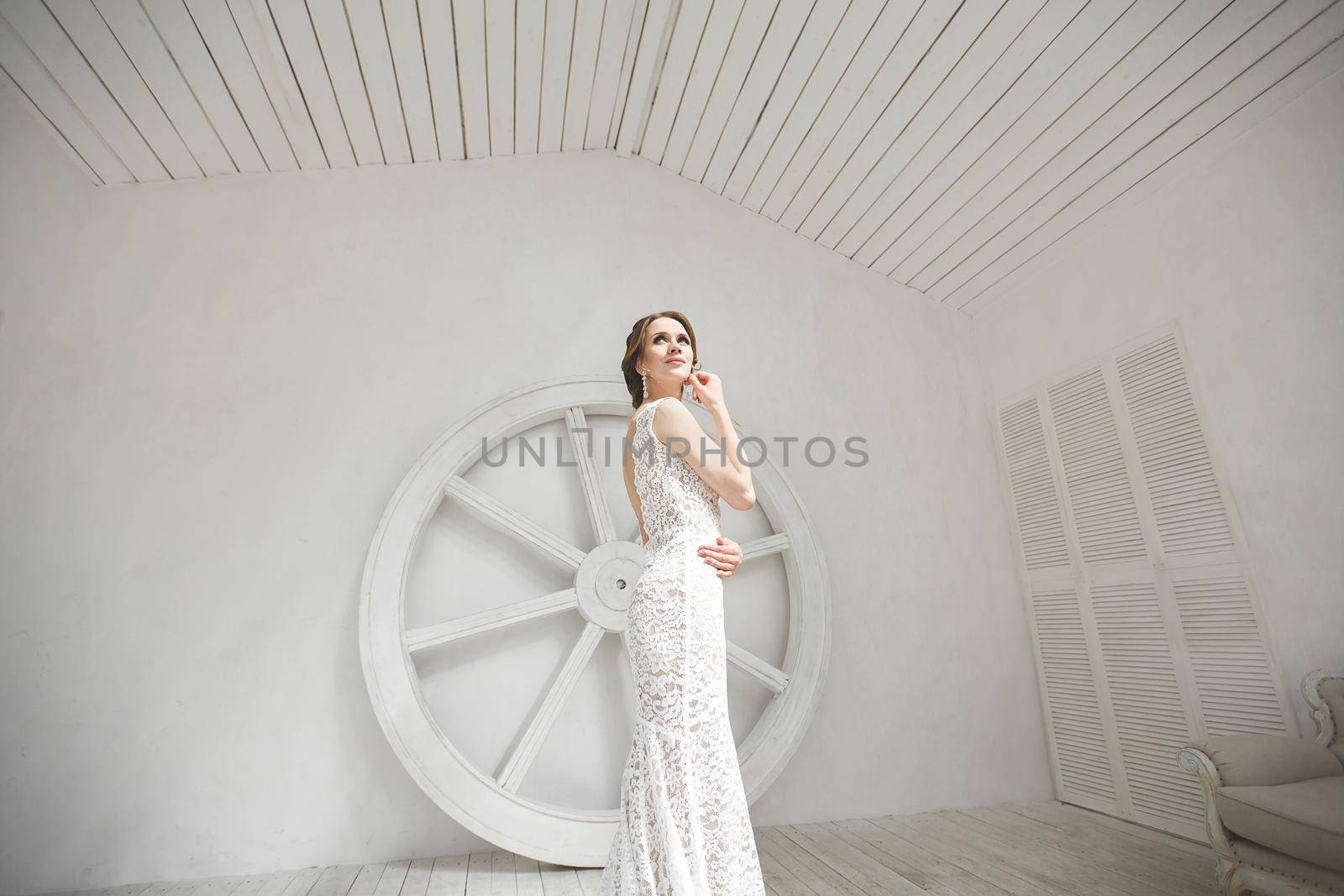 Beautiful bride posing in wedding dress in a white photo Studio. by StudioPeace