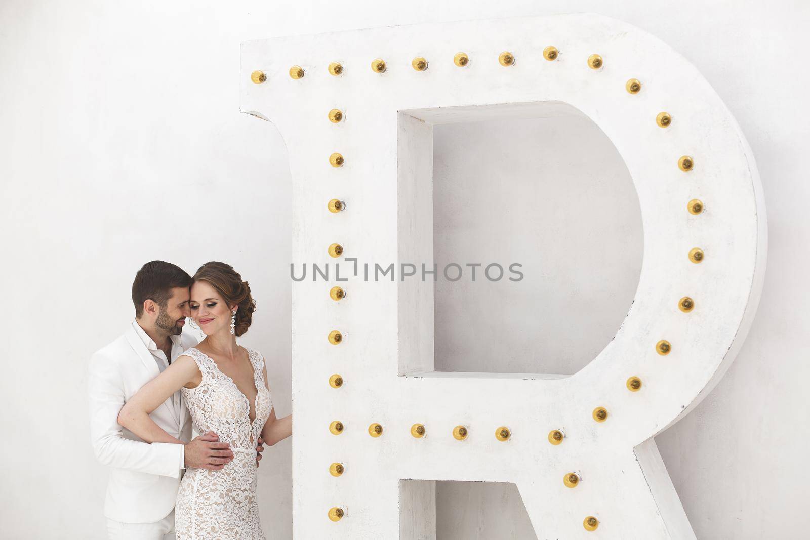 Chic wedding couple groom and bride posing in a white Studio. by StudioPeace