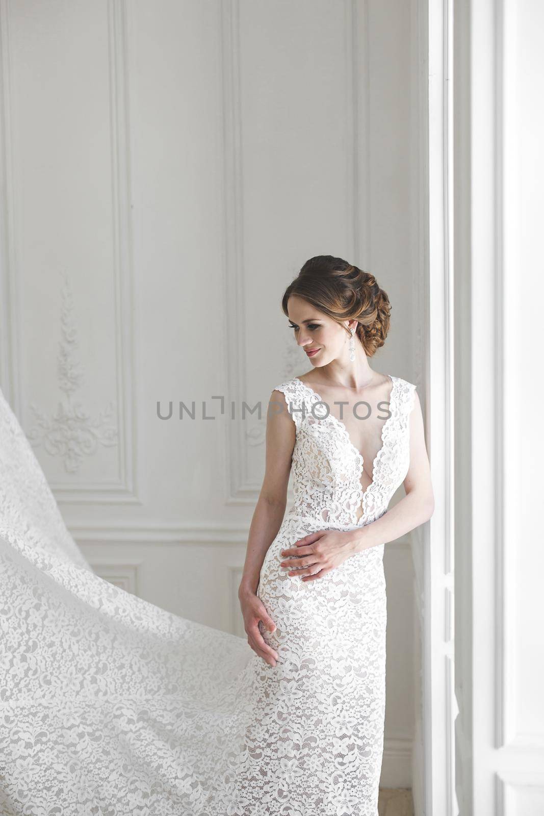 Beautiful bride posing in wedding dress in a white photo Studio.