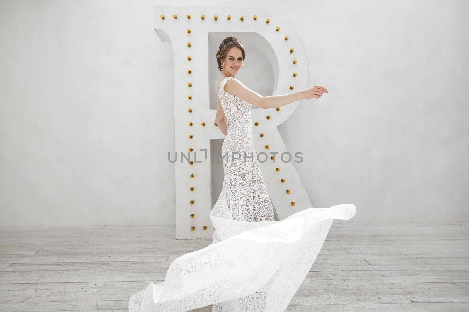 Beautiful bride posing in wedding dress in a white photo Studio.