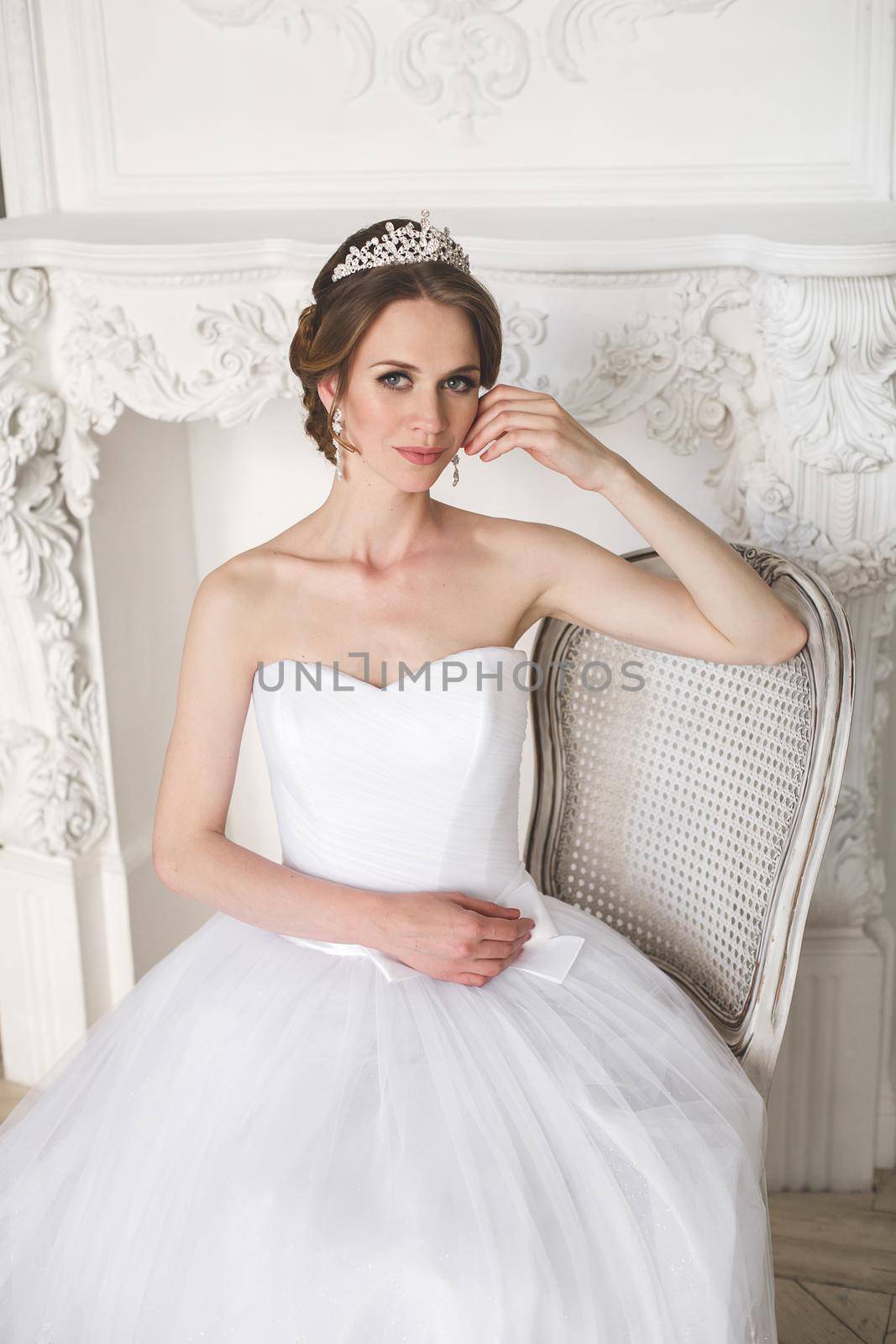 Beautiful bride posing in wedding dress in a white photo Studio.