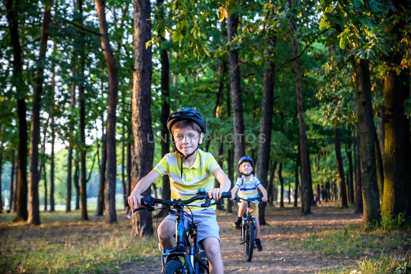 Two little boys children having fun on Balance Bike on a country road. Healthy lifestyle concept