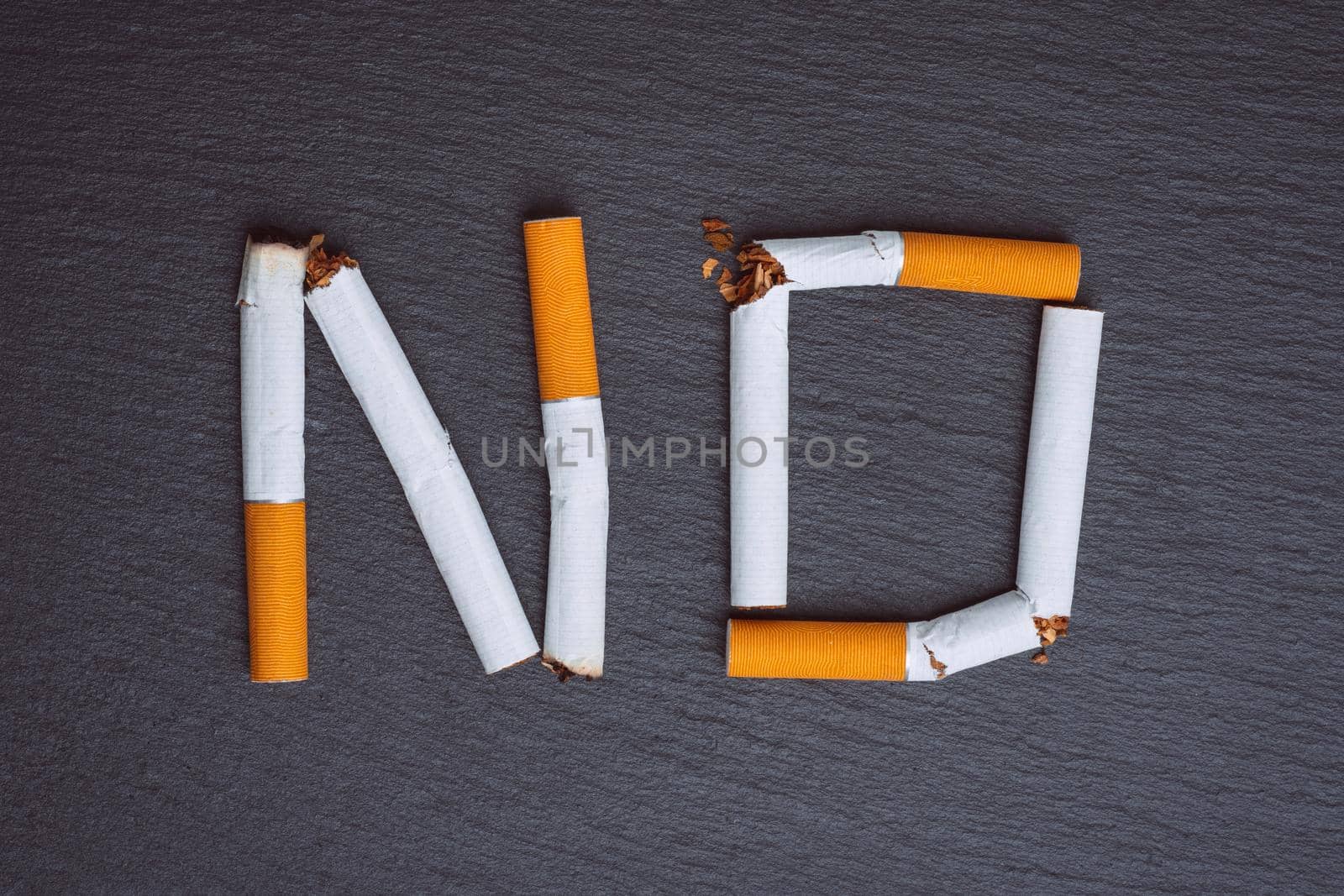 No smoking word made from broken cigarettes on a black background. High quality photo