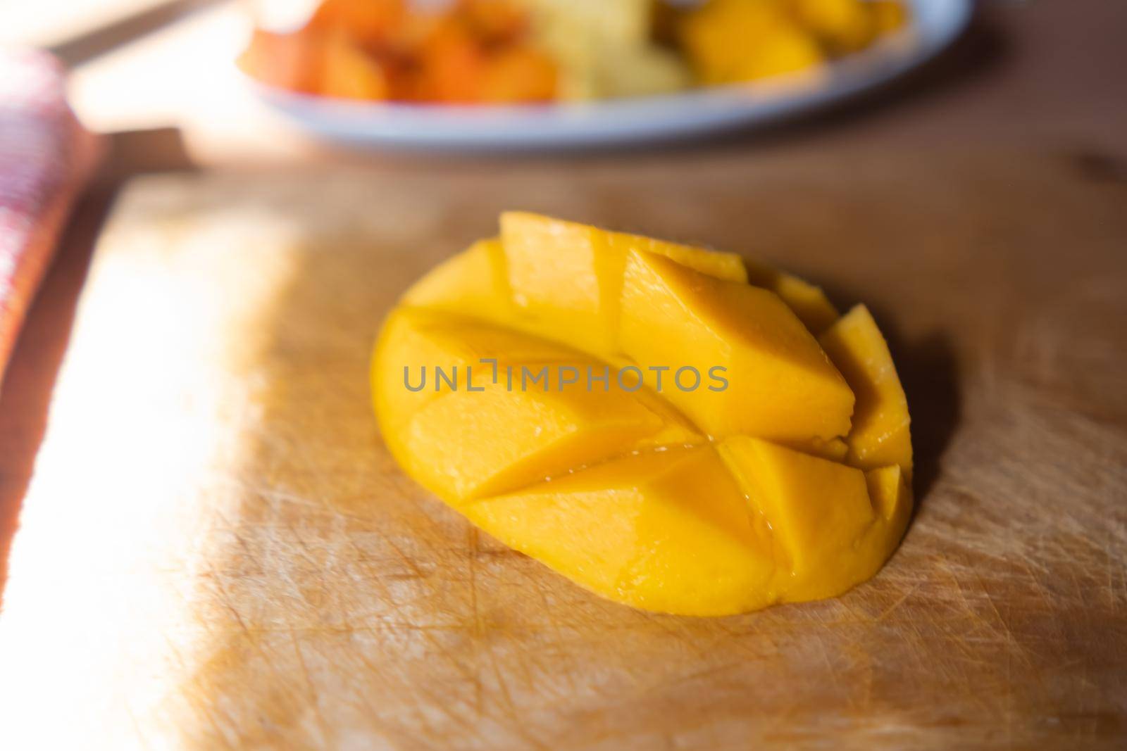 Close-up of diced mango on wooden cutting board by Kanelbulle