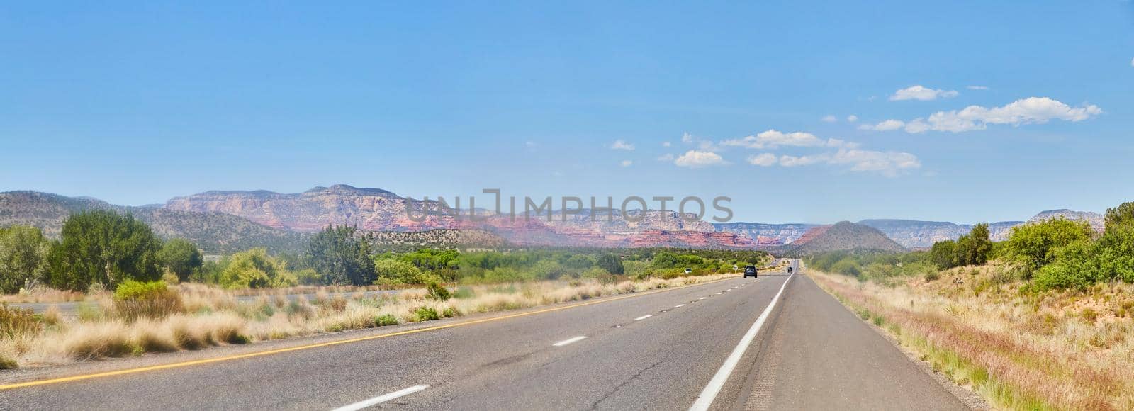 Image of Panorama of desert road with red mountains on horizon