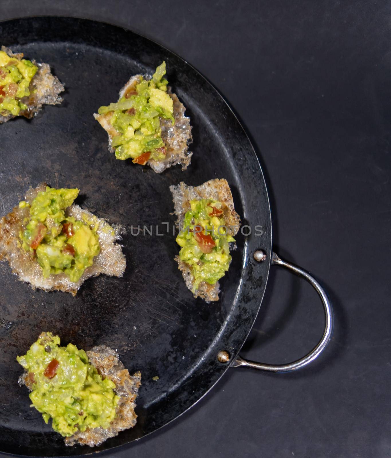 Pork rinds with guacamole on traditional Mexican comal by Kanelbulle
