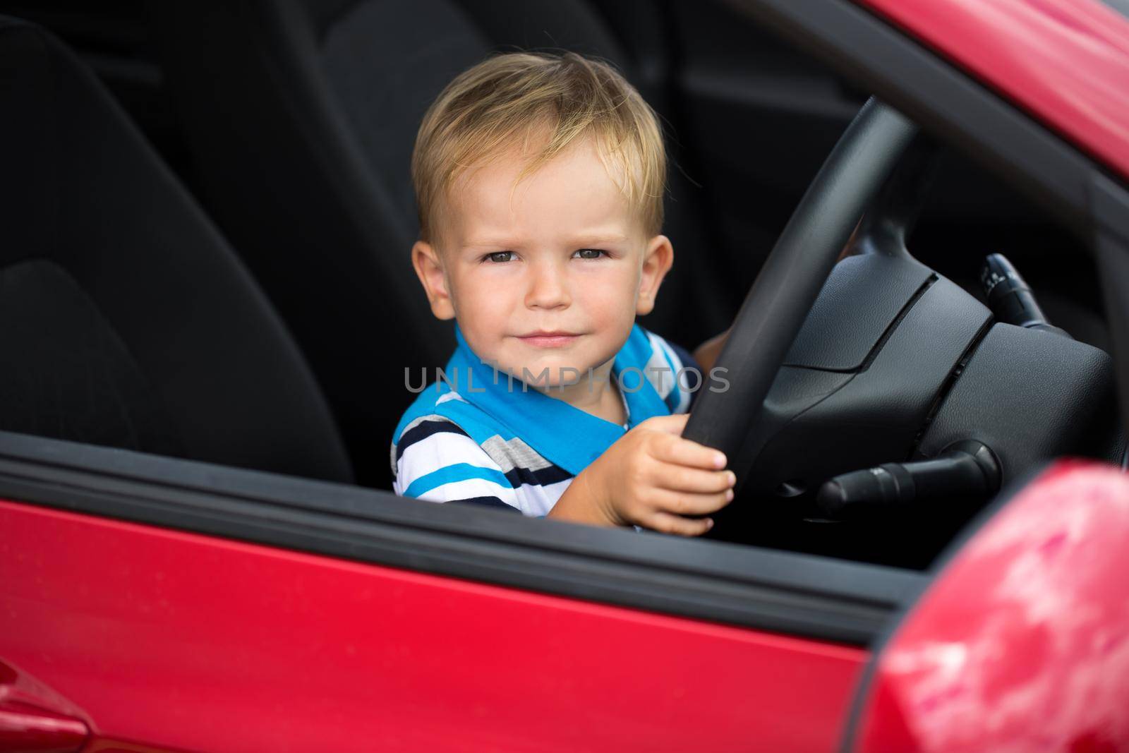 Cute little boy driving his father's car. by StudioPeace