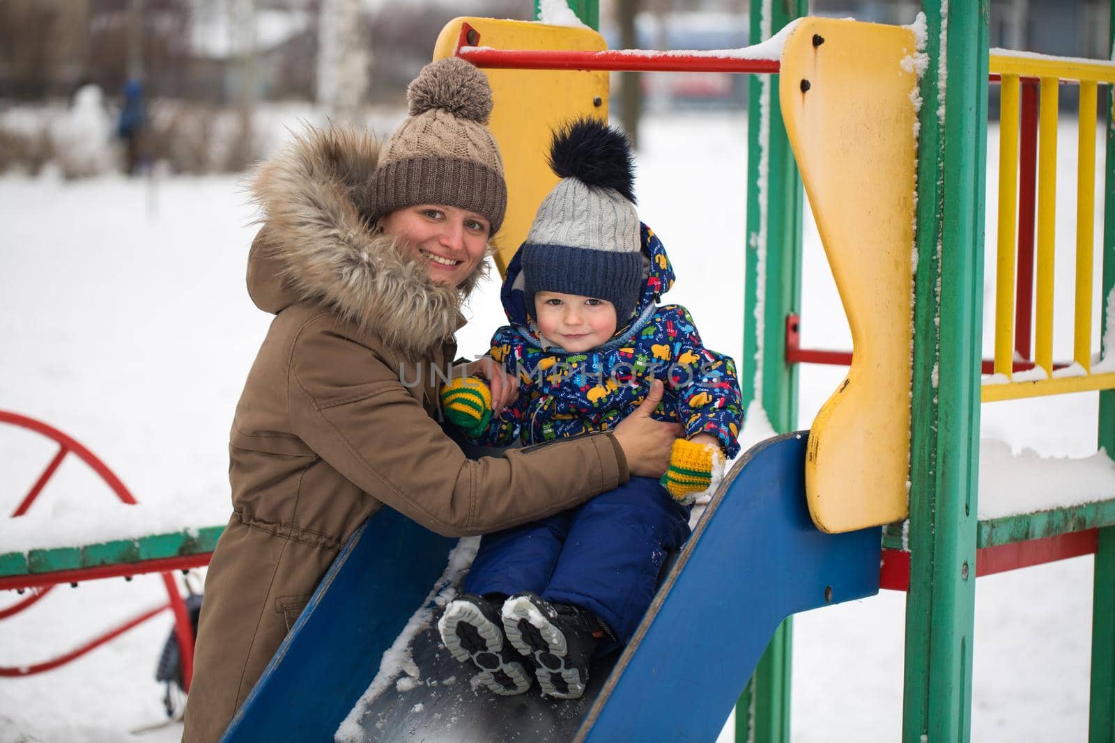 happy mother and baby in winter park. family outdoors. cheerful mommy with her child. by StudioPeace