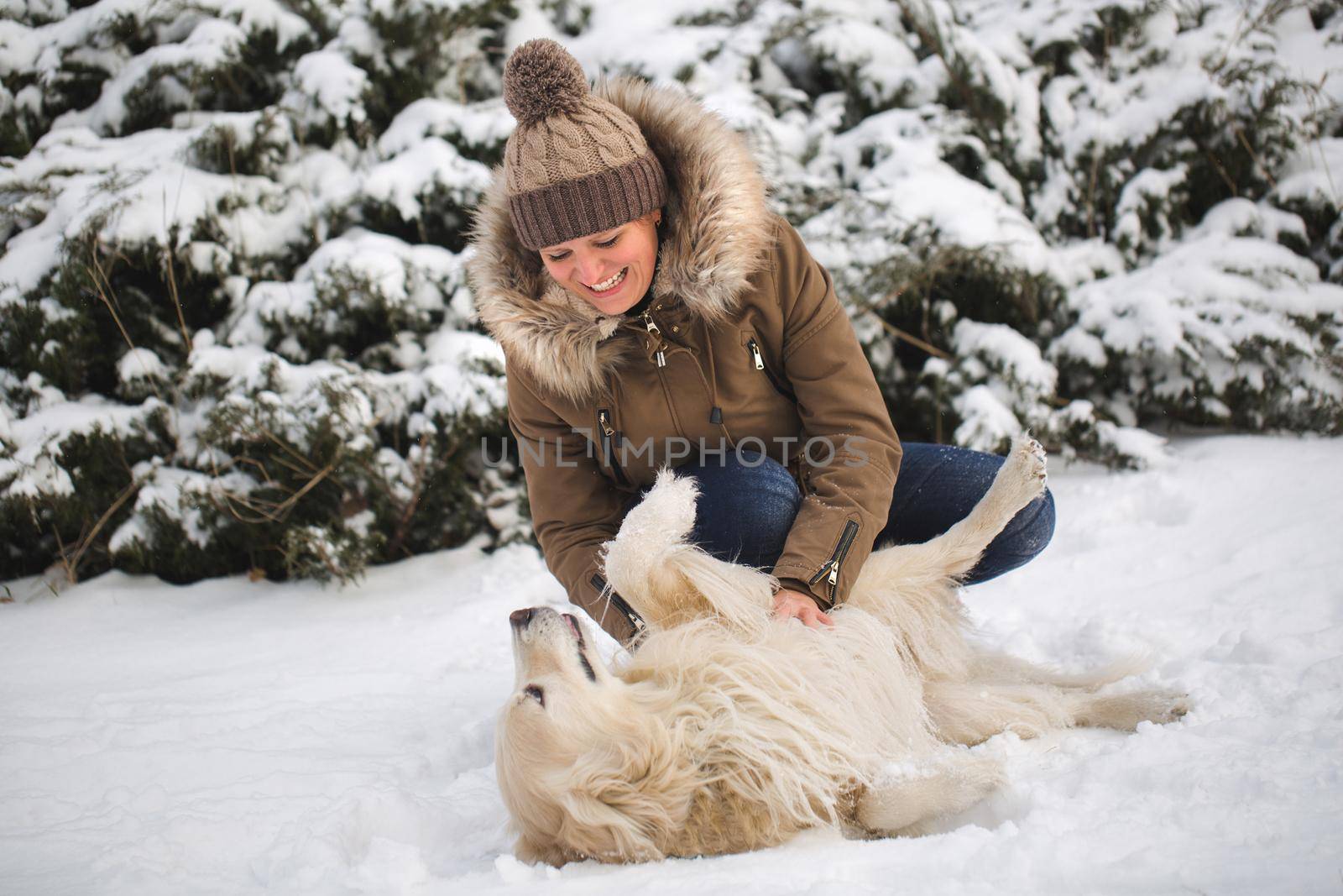 Beautiful girl playing with her dog in the snow. Golden Retriever. by StudioPeace