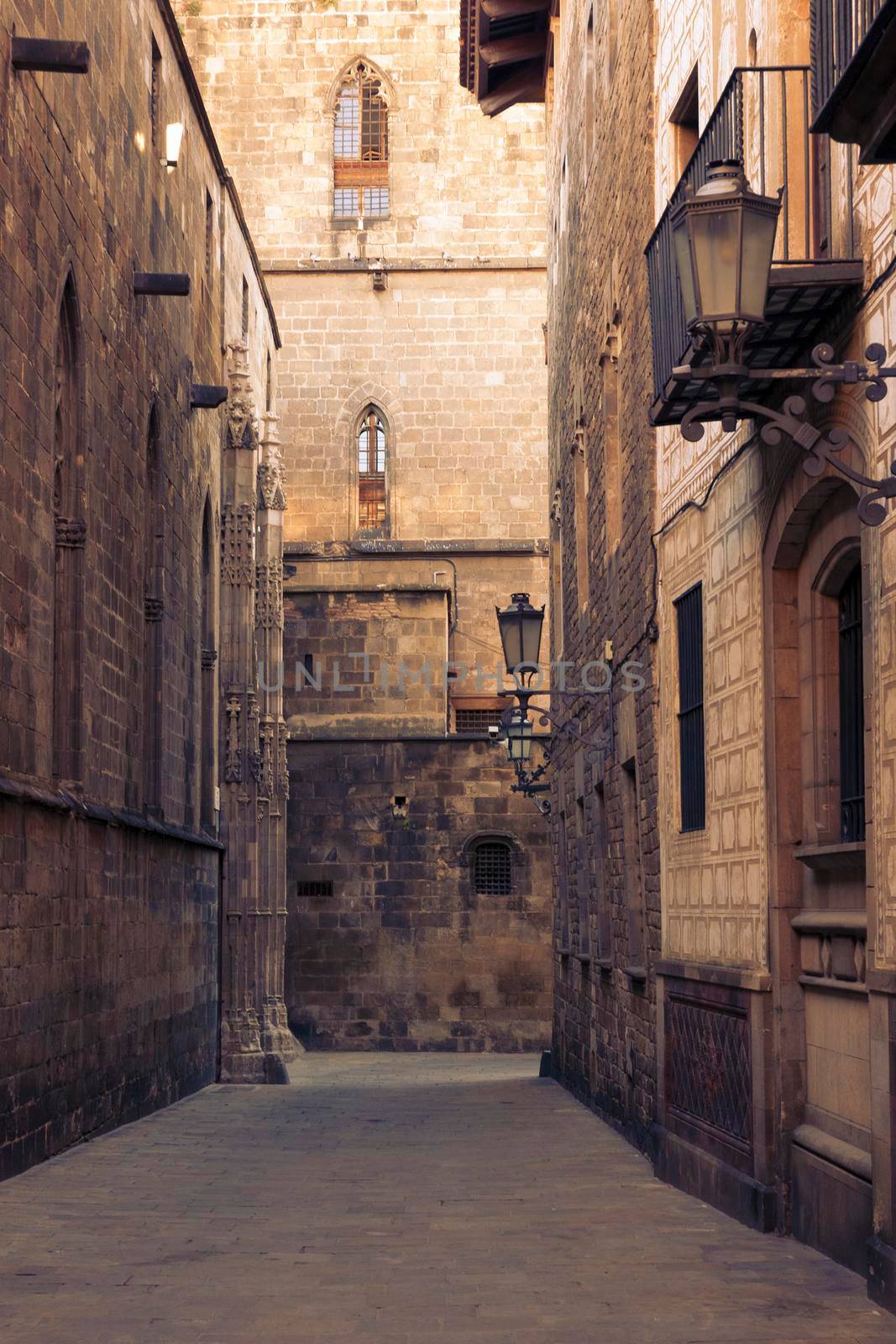 narrow space between tall medieval buildings in famous Gothic Quarter in Barcelona