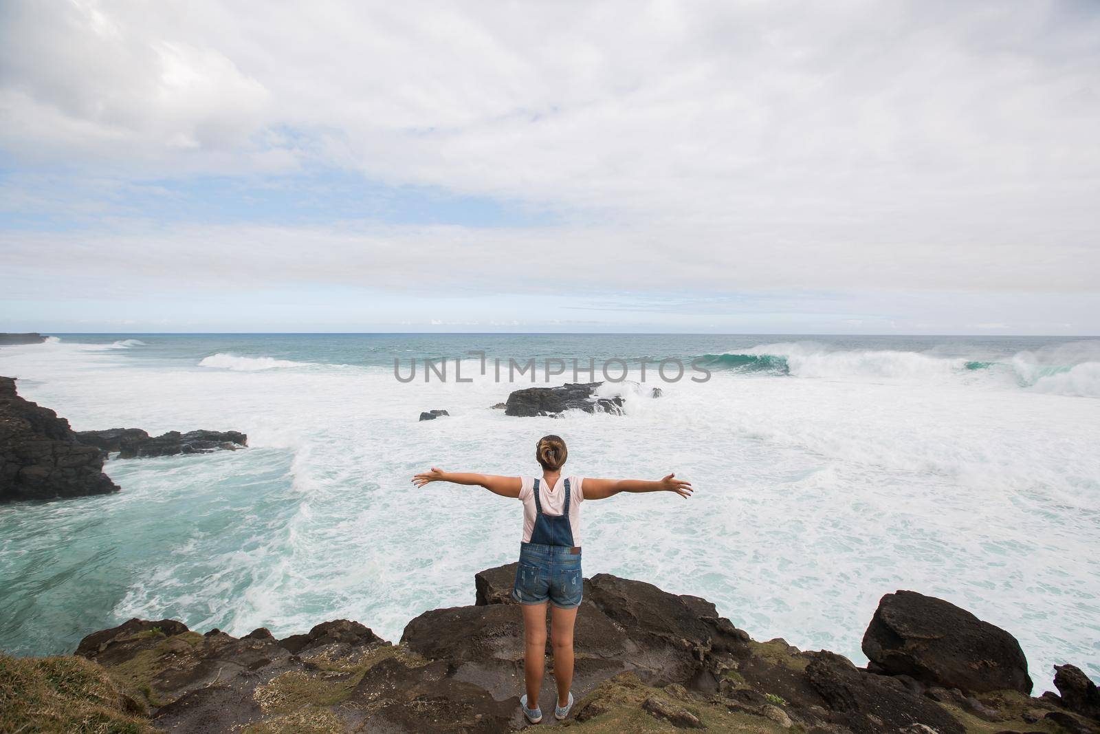 Freedom traveler woman standing with raised arms on the top of mountain and enjoy the beautiful of seascape. Mauritius