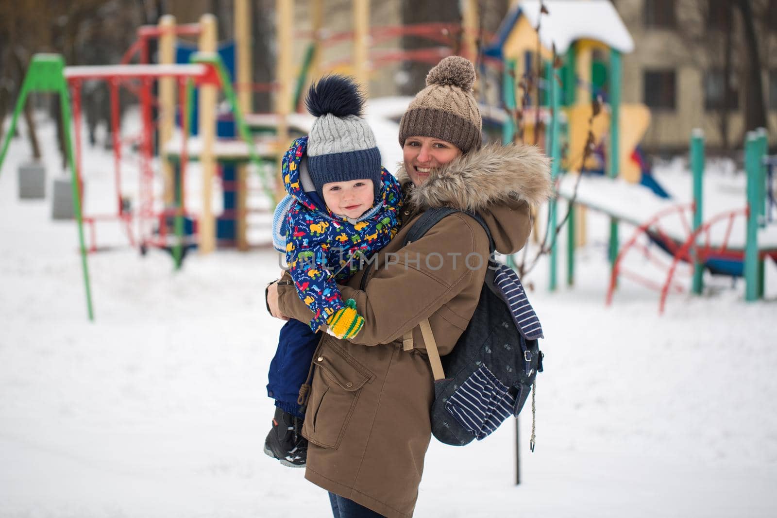 happy mother and baby in winter park. family outdoors. cheerful mommy with her child. by StudioPeace