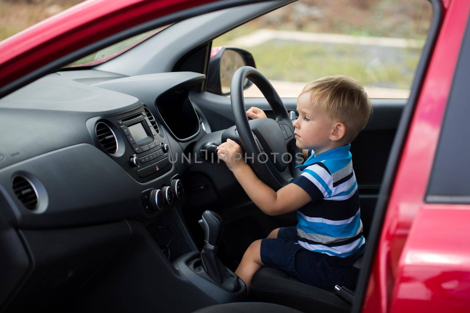 Cute little boy driving his father's car