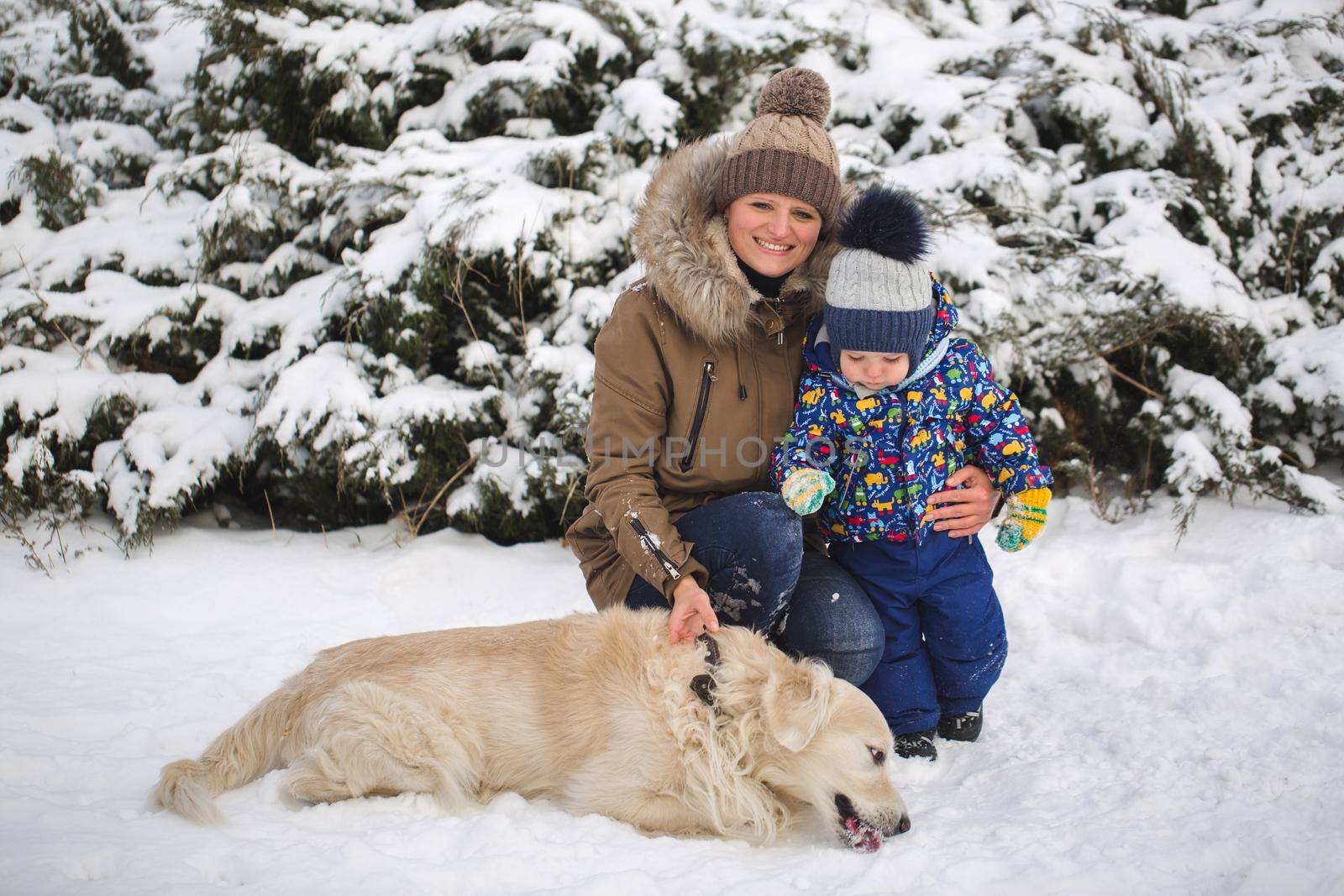 Beautiful mother and son playing with my dog in the snow. Golden Retriever. by StudioPeace