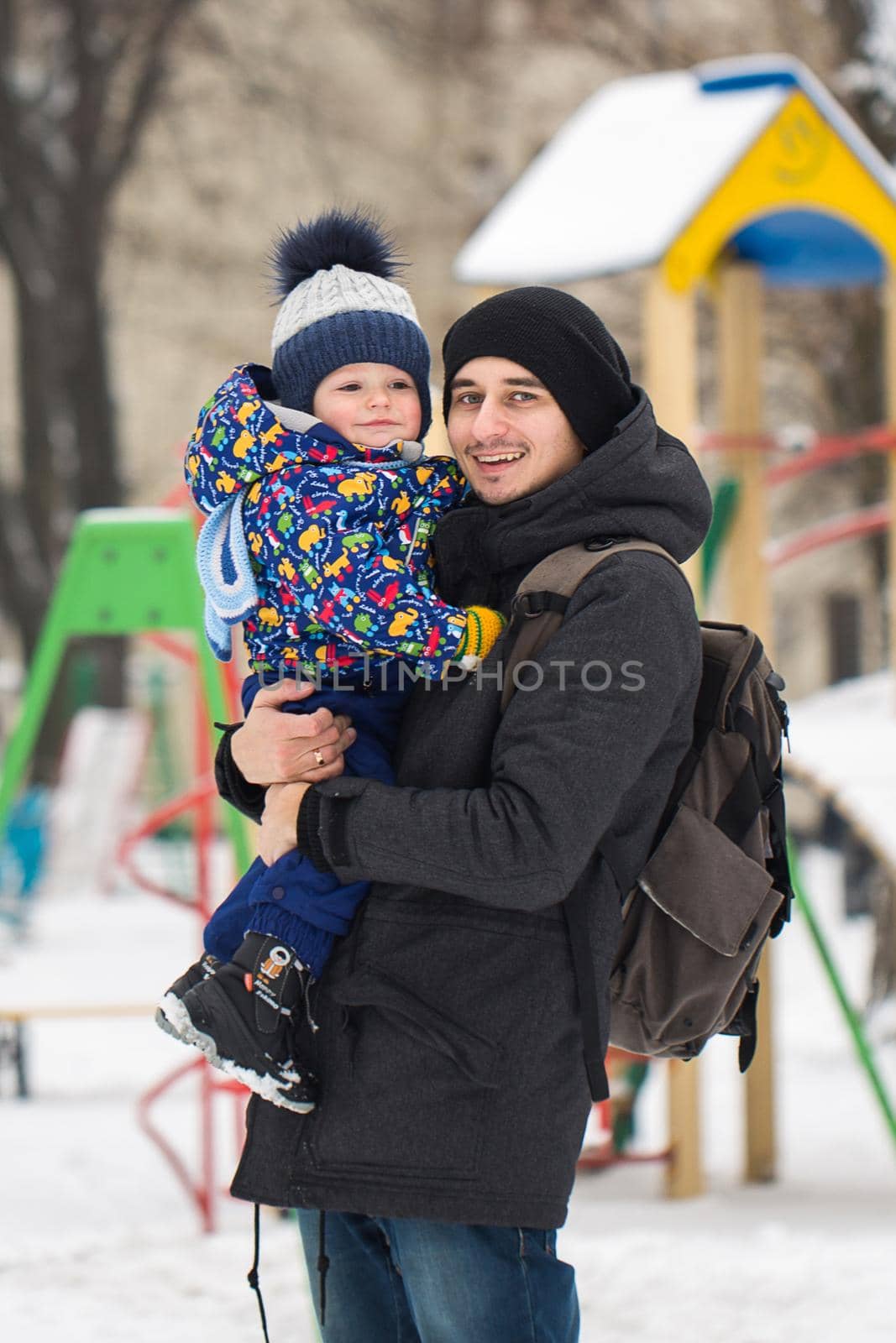 The little boy in the hands of his father in the winter weather. Walk in the Park in the snow.