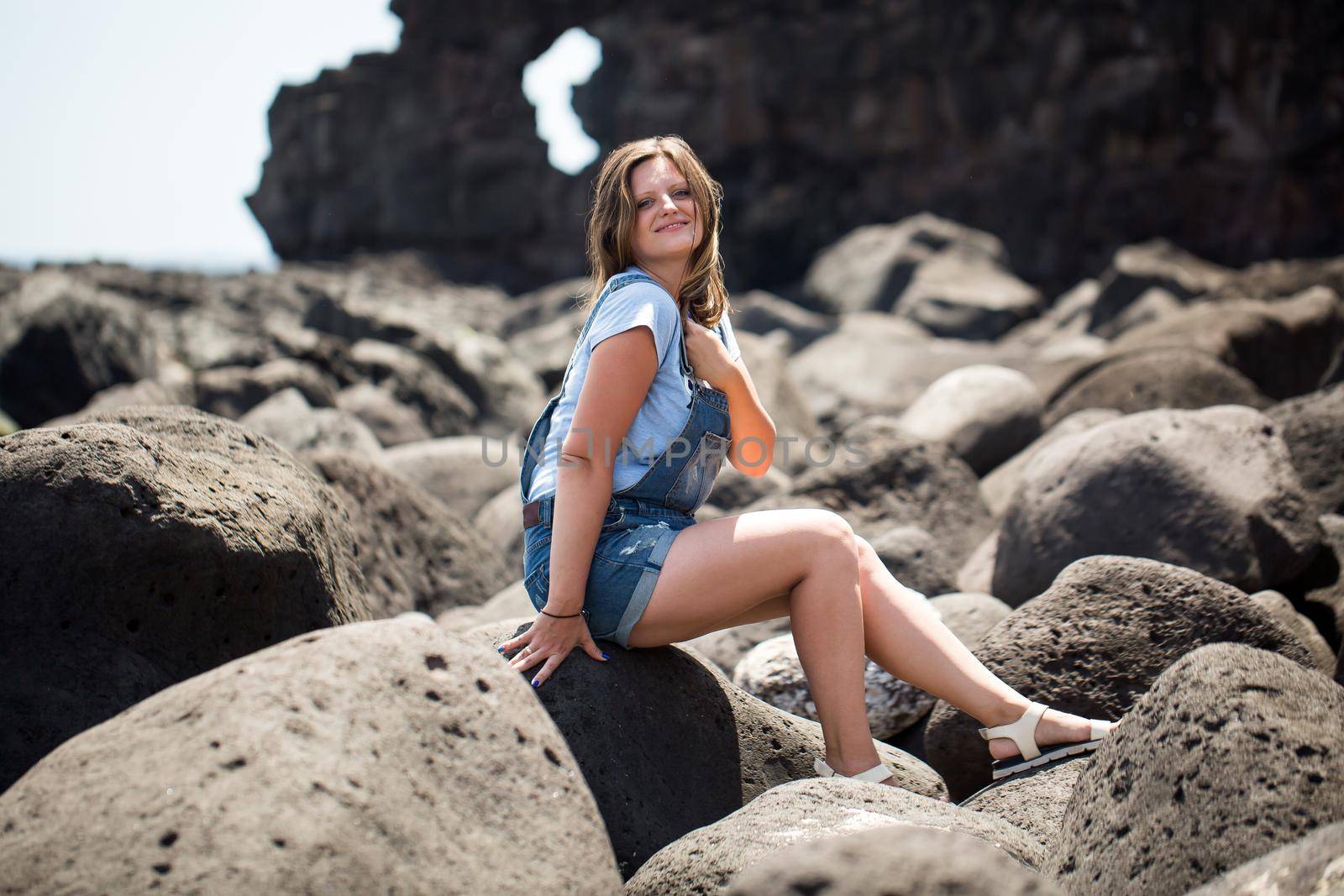 Young beautiful woman sitting on the stone