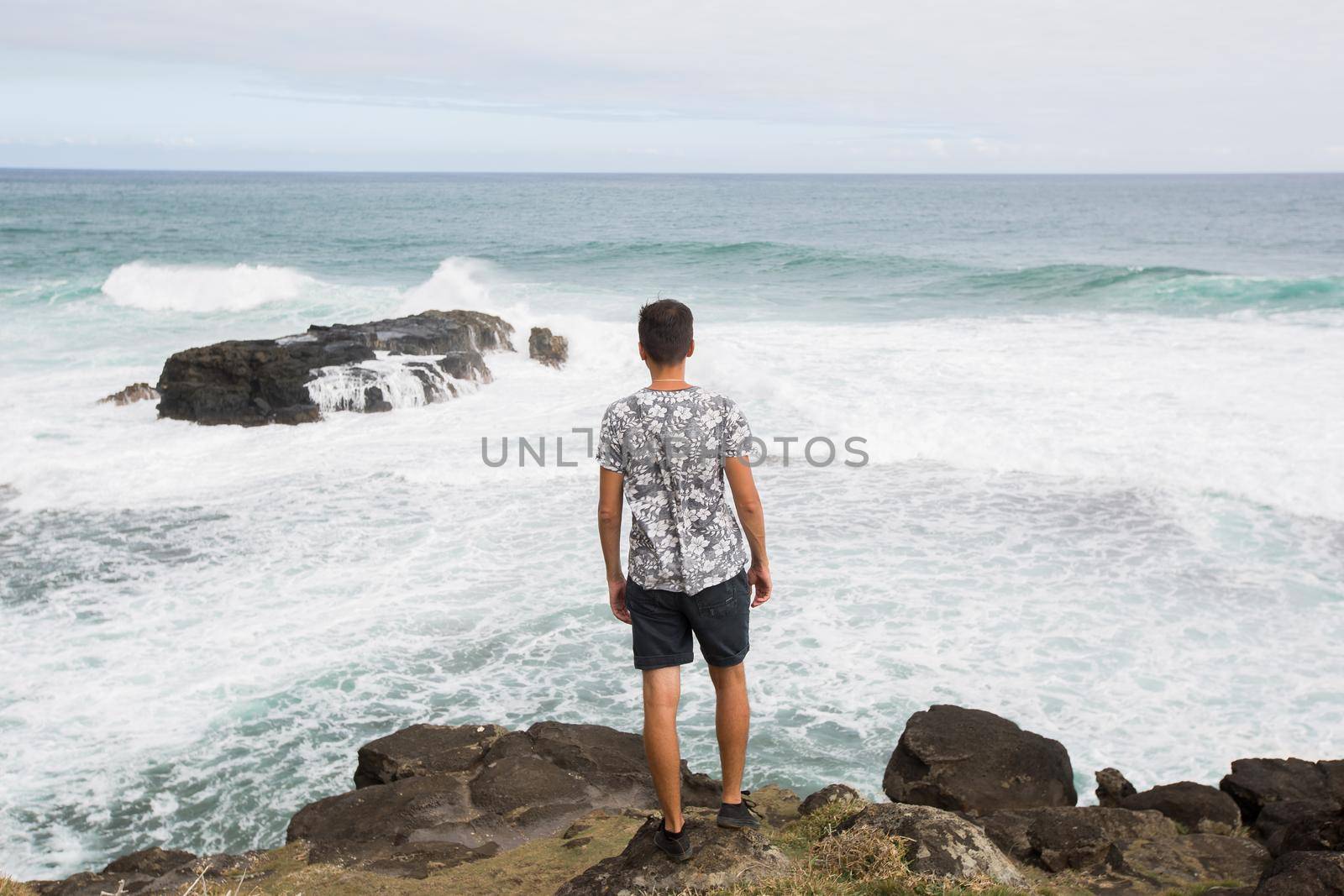 Happy man standing on the peak of the mountain, over looking the ocean. Success, winner, happiness by StudioPeace
