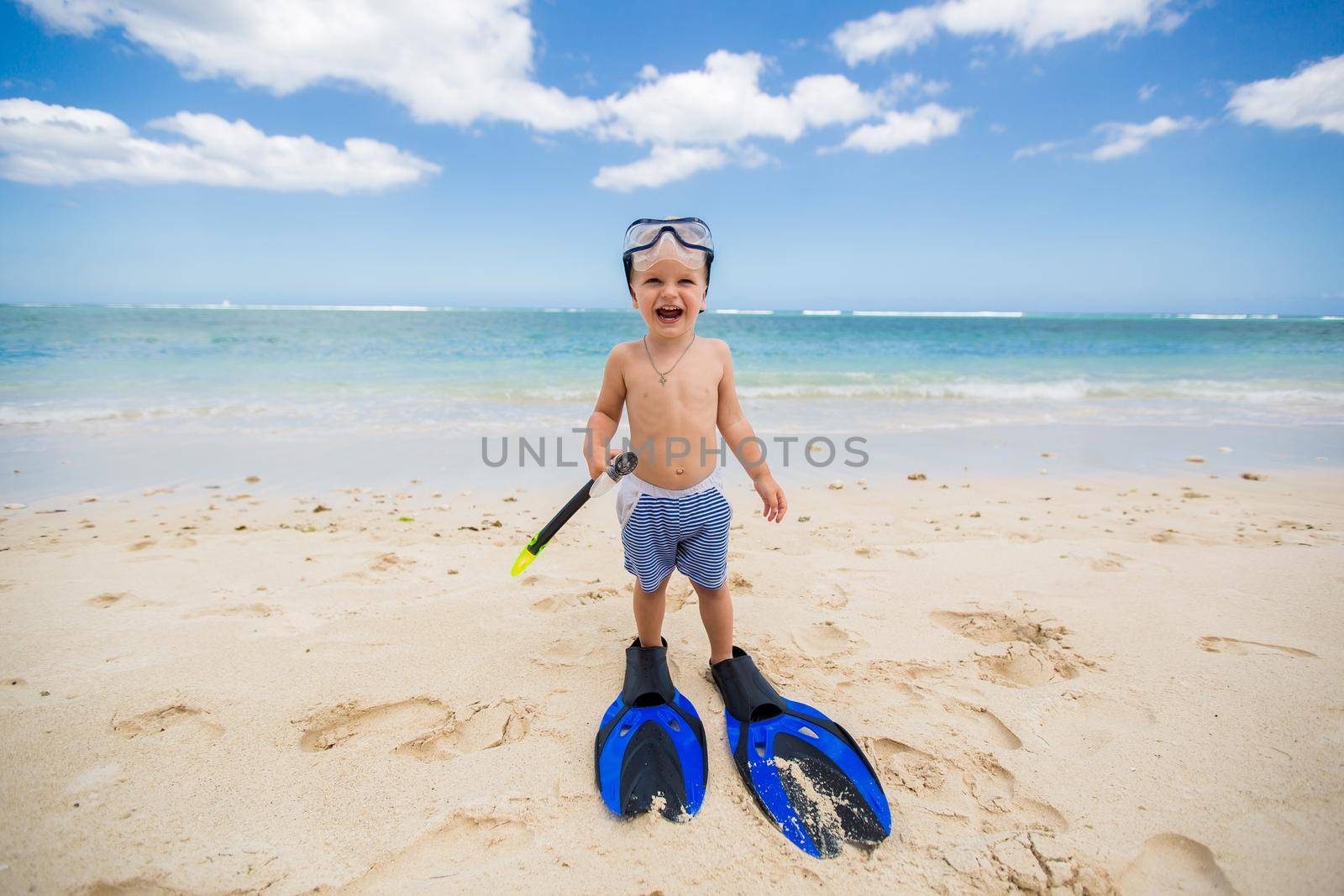 Little boy with diving mask and fins go swim at beach