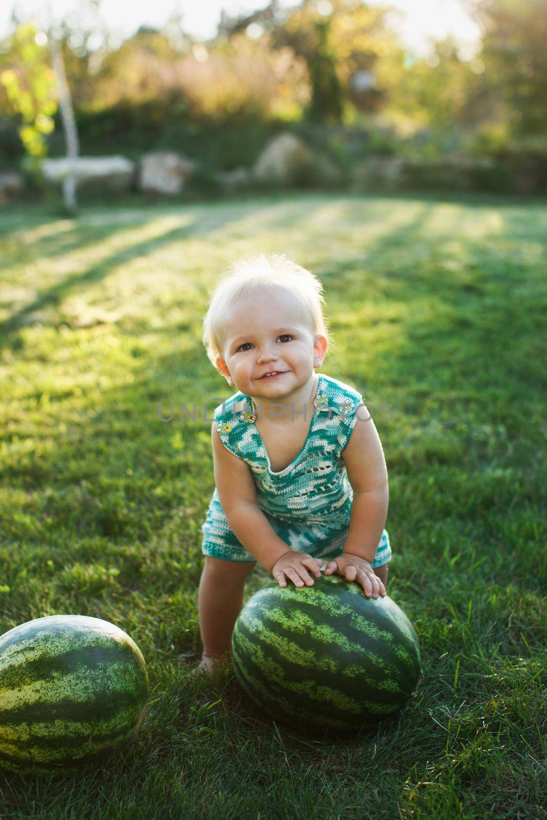 Little boy with a watermelon sitting on the grass. by StudioPeace