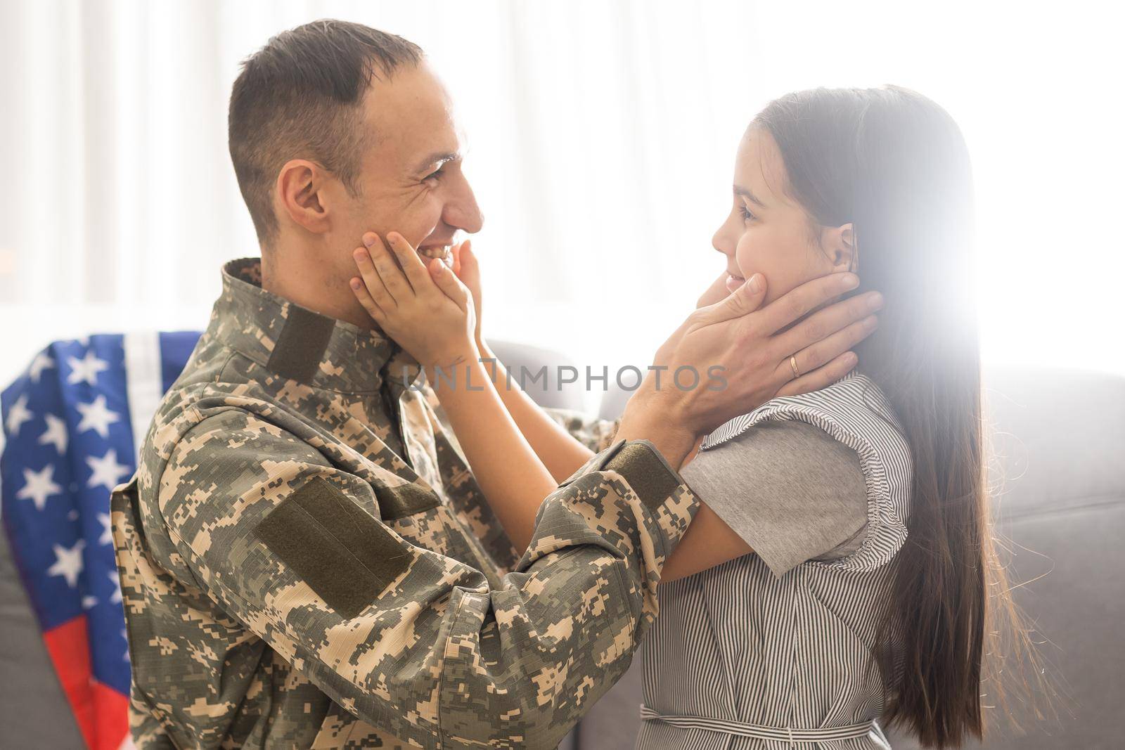 Soldier with flag of USA and his little daughter hugging, space for text.