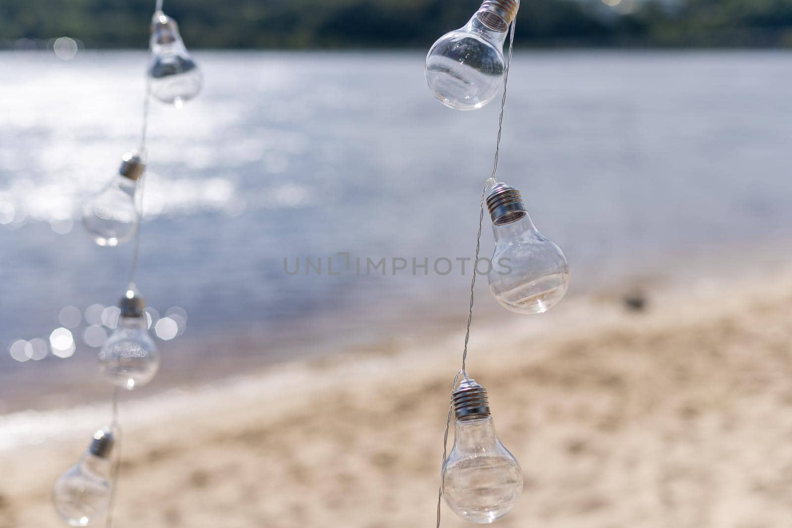 Hanging light bulbs on a background of water.