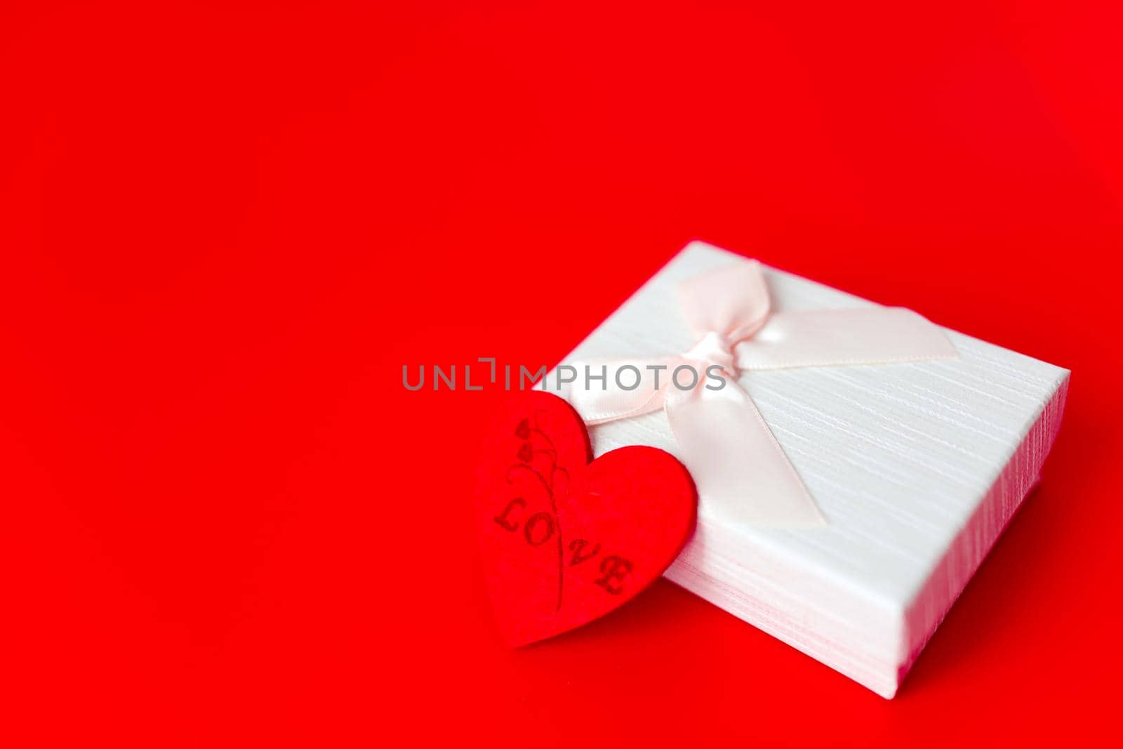 Gift box on red background. Romantic st. Valentine's day concept of greetings. place for your text by lifesummerlin