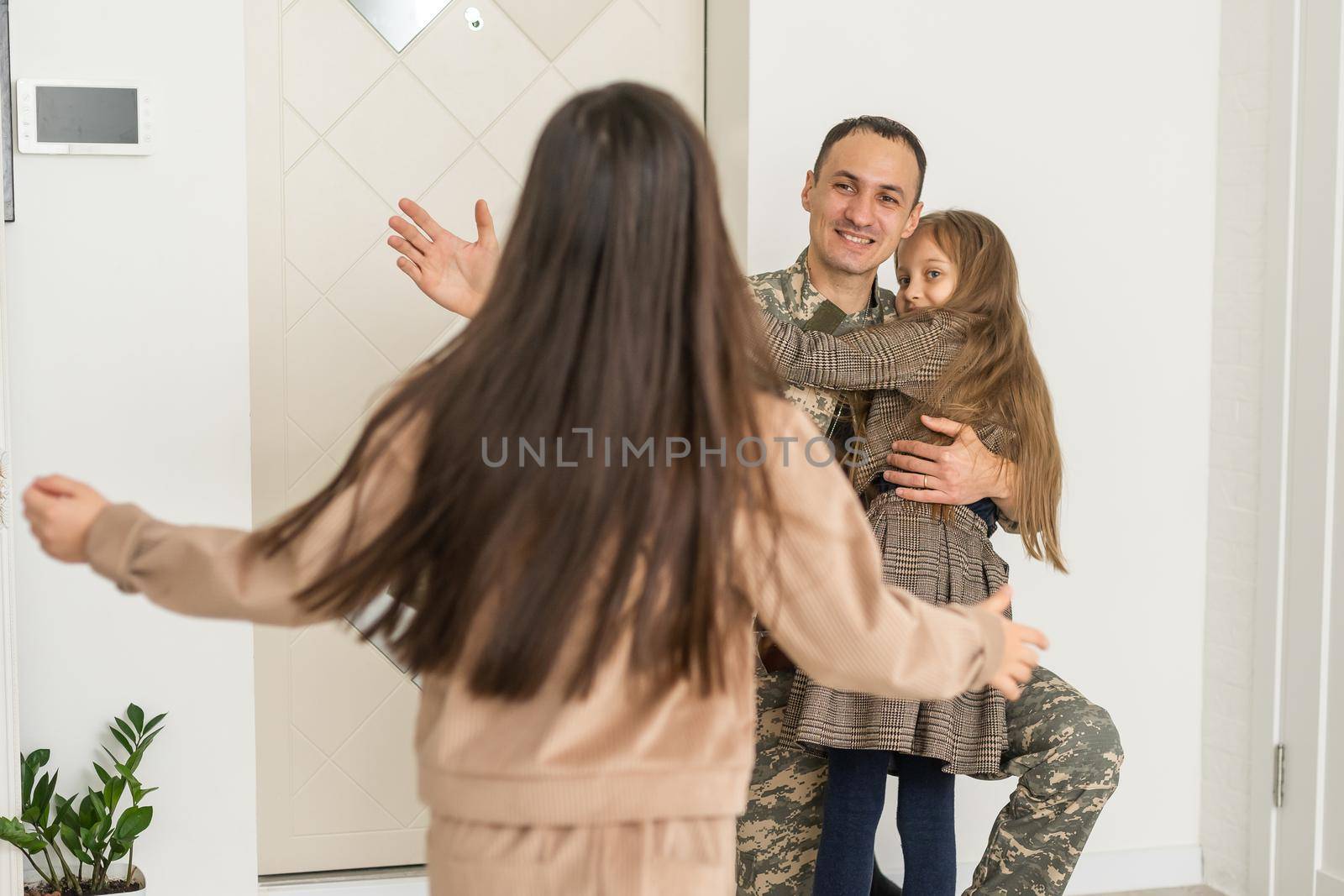 Happy military father and two daughters at home