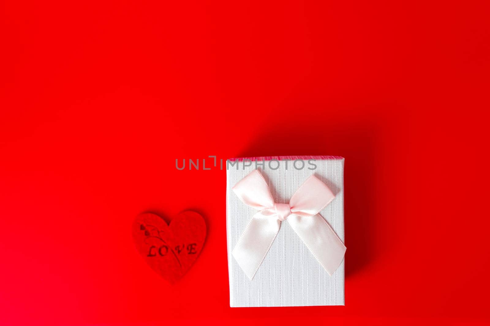 Gift box on red background. Romantic st. Valentine's day concept of greetings. place for your text by lifesummerlin