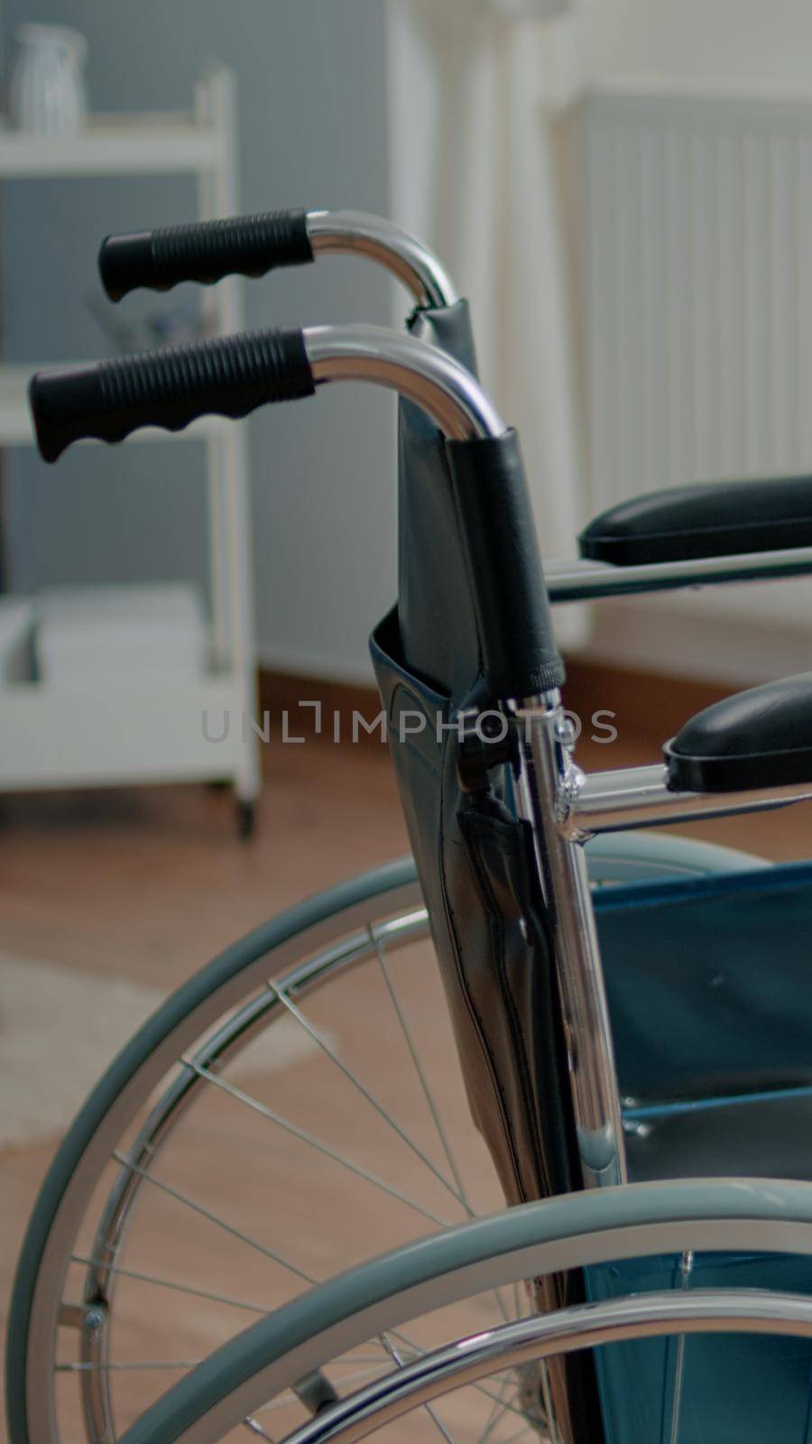 Close up of wheelchair in empty room at nursing home. Transportation object for disabled and handicapped patients, with medical equipment at facility. Nobody in space for recovery