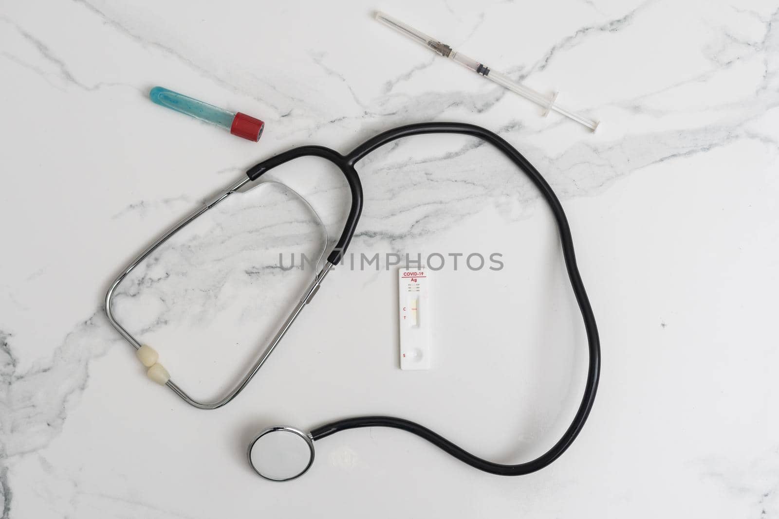 Medical layout on white background, flat lay. stethoscope or phonendoscope surrounded by vials, ampoules and test tubes