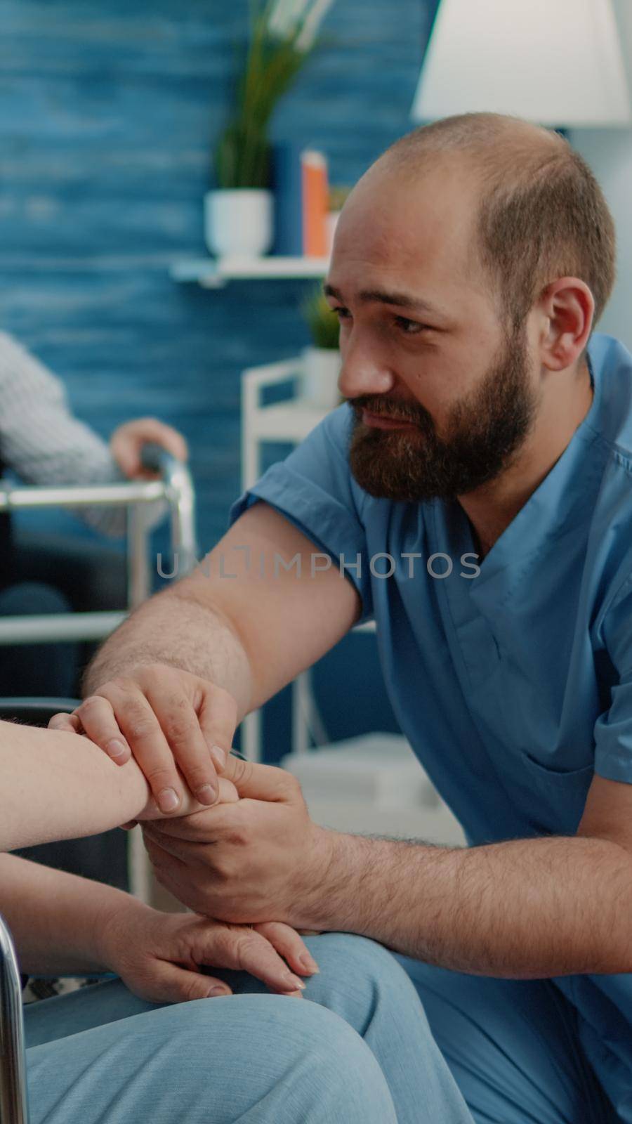 Man nurse comforting senior woman with chronic issues by DCStudio