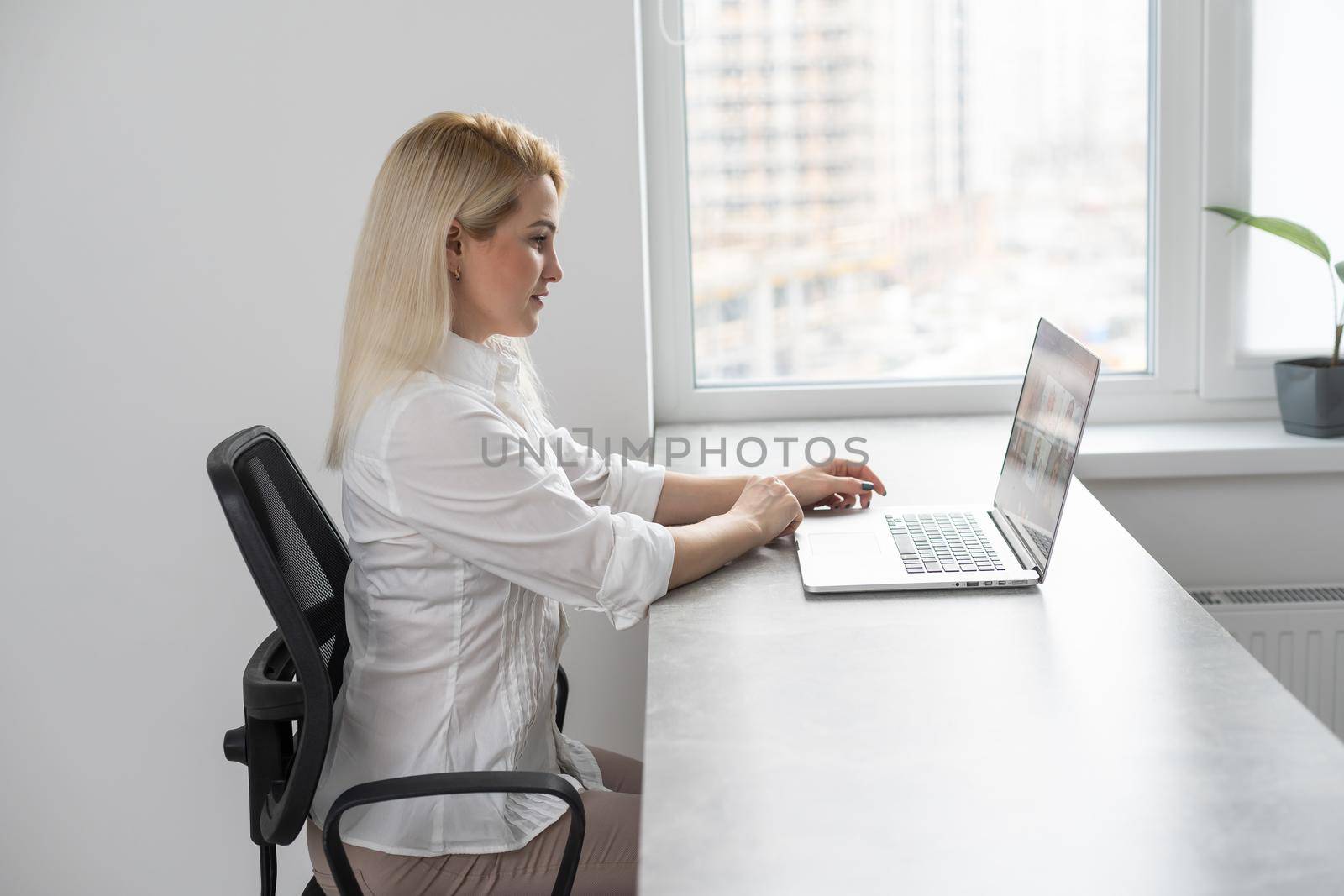 Shot of an attractive businesswoman working on laptop in her workstation. by Andelov13