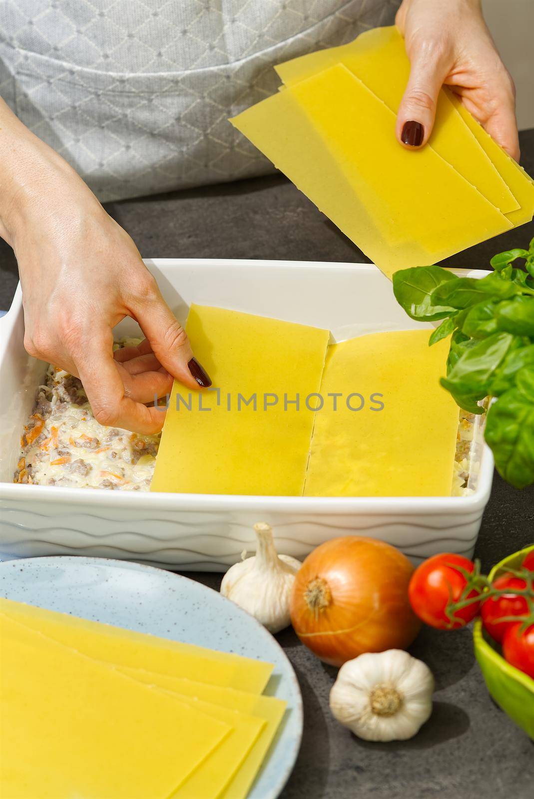 Woman preparing meat lasagna in kitchen. lasagna recipe - Italian food by PhotoTime